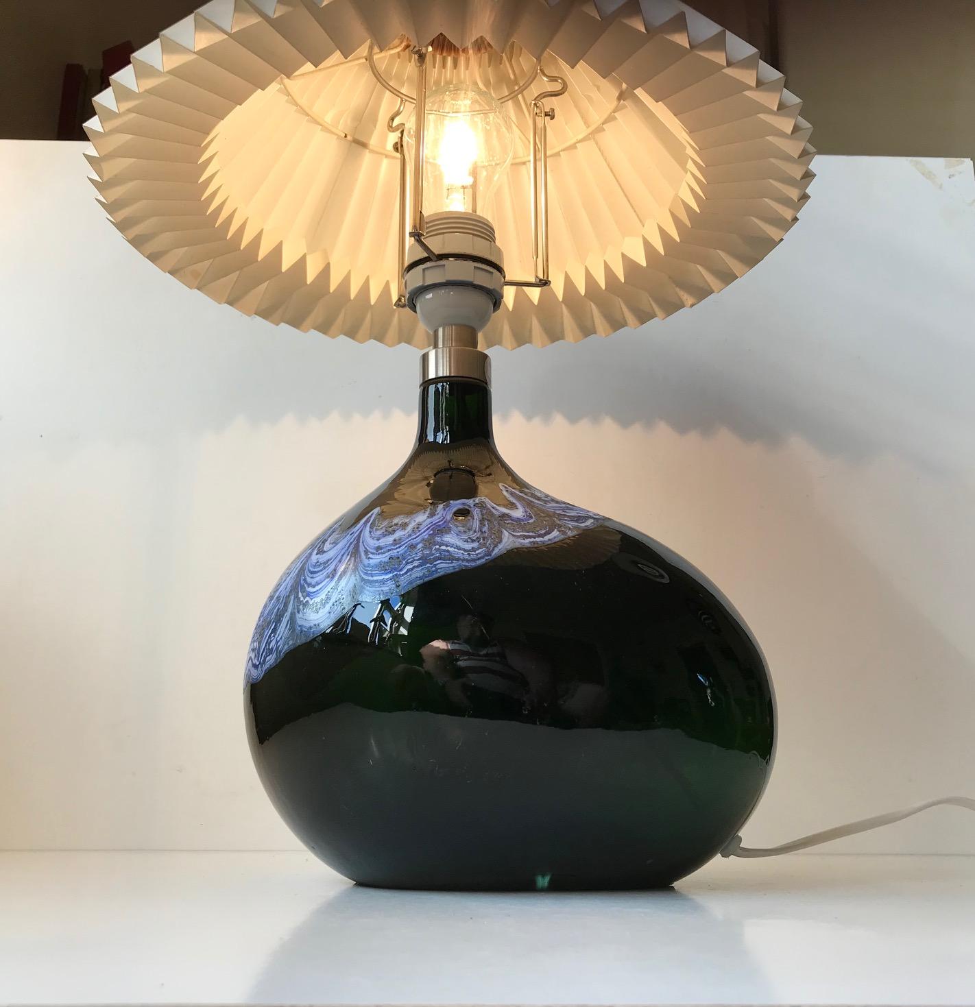 Rare freeform black art glass table lamp designed by Michael Bang and manufactured by Holmegaard in Denmark only from 1973-1976. It is decorated with wavy blue and white enamel applied by hand and therefore unique to this light. This model is called