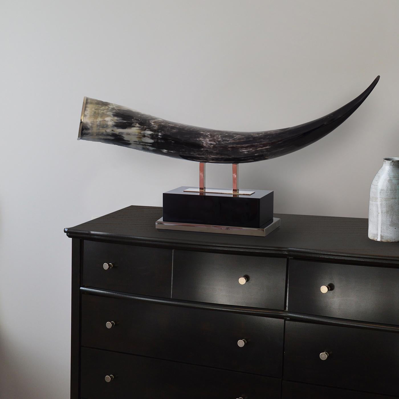 Mounted on a rectangular base of black resin adorned with nickel-finished brass details, this sculpture will make a statement in the dining room or living room. Made of a genuine horn polished and treated with natural wax to preserve and protect its