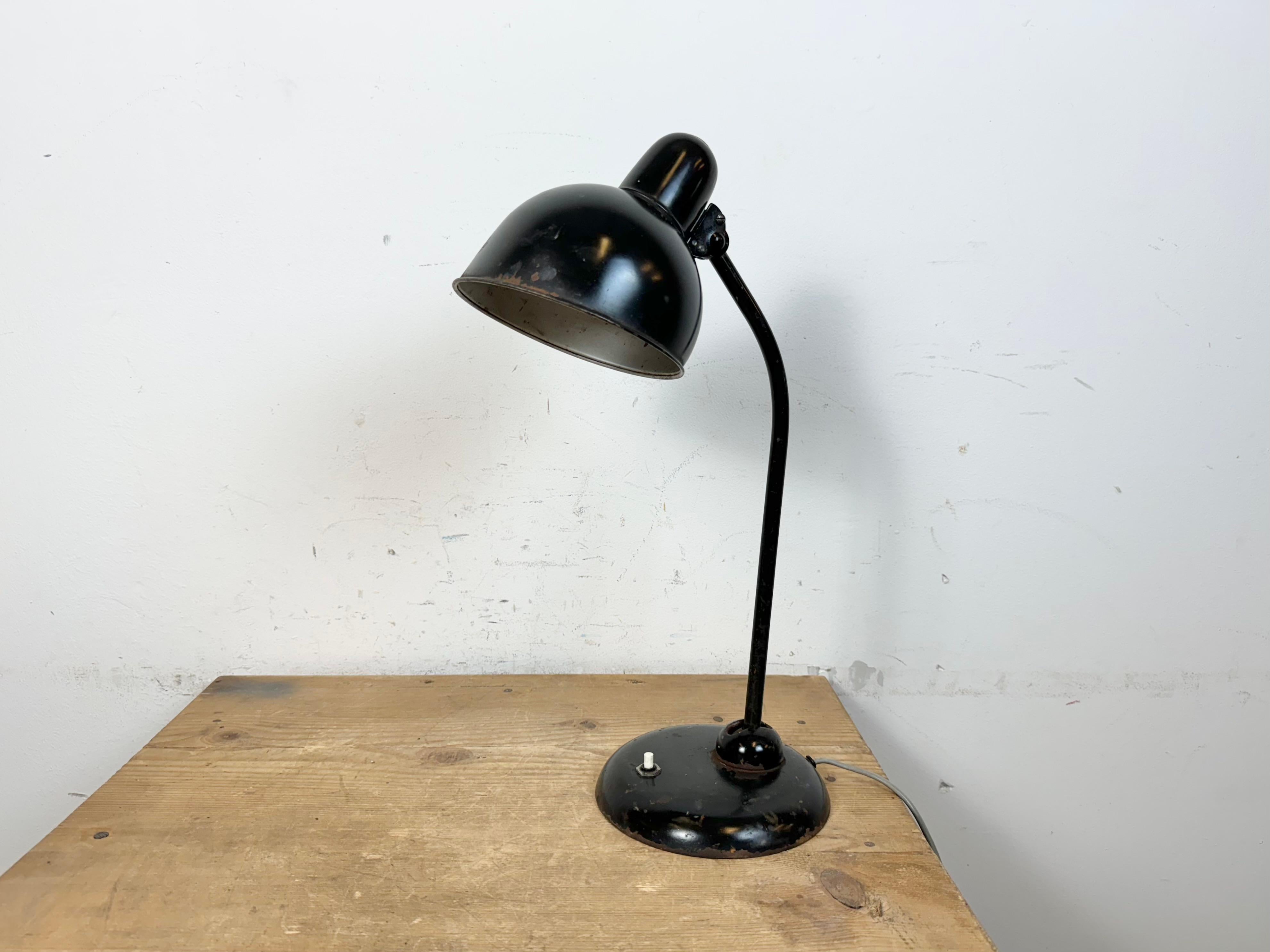 Esta lámpara de escritorio industrial Bauhaus negra con dos articulaciones ajustables se fabricó en la antigua Checoslovaquia durante la década de 1930. Tiene una pantalla de metal negro,un brazo de hierro y una base de hierro fundido con