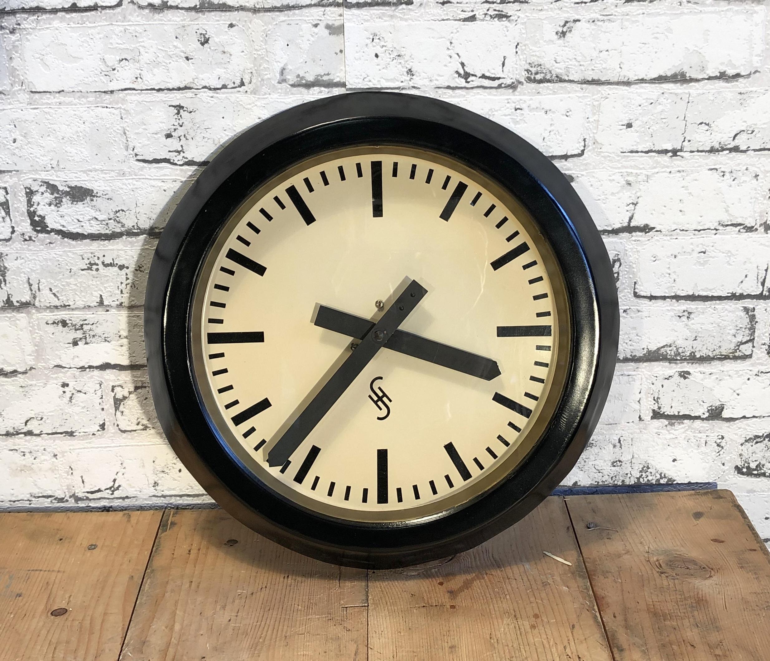 This wall clock was produced by Siemens and Halske in Germany during the 1950s. It features a black metal frame, aluminum dial, and a clear glass cover. The piece has been converted into a battery-powered clockwork and requires only one AA-battery.
