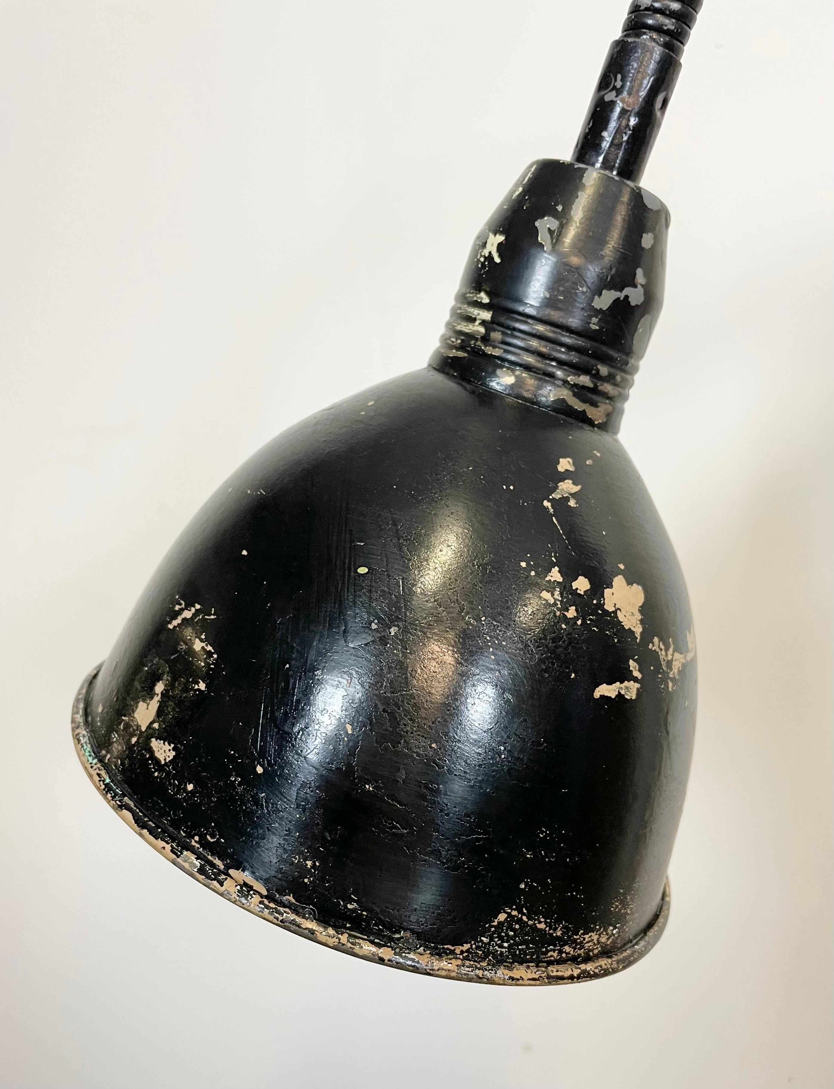 This black vintage Industrial scissor wall lamp was produced by Elektroinstala in former Czechoslovakia during the 1960s. It has a metal lampshade. The iron scissor arm is extendable and can be turned sideways. The socket requires E 27 lightbulbs .
