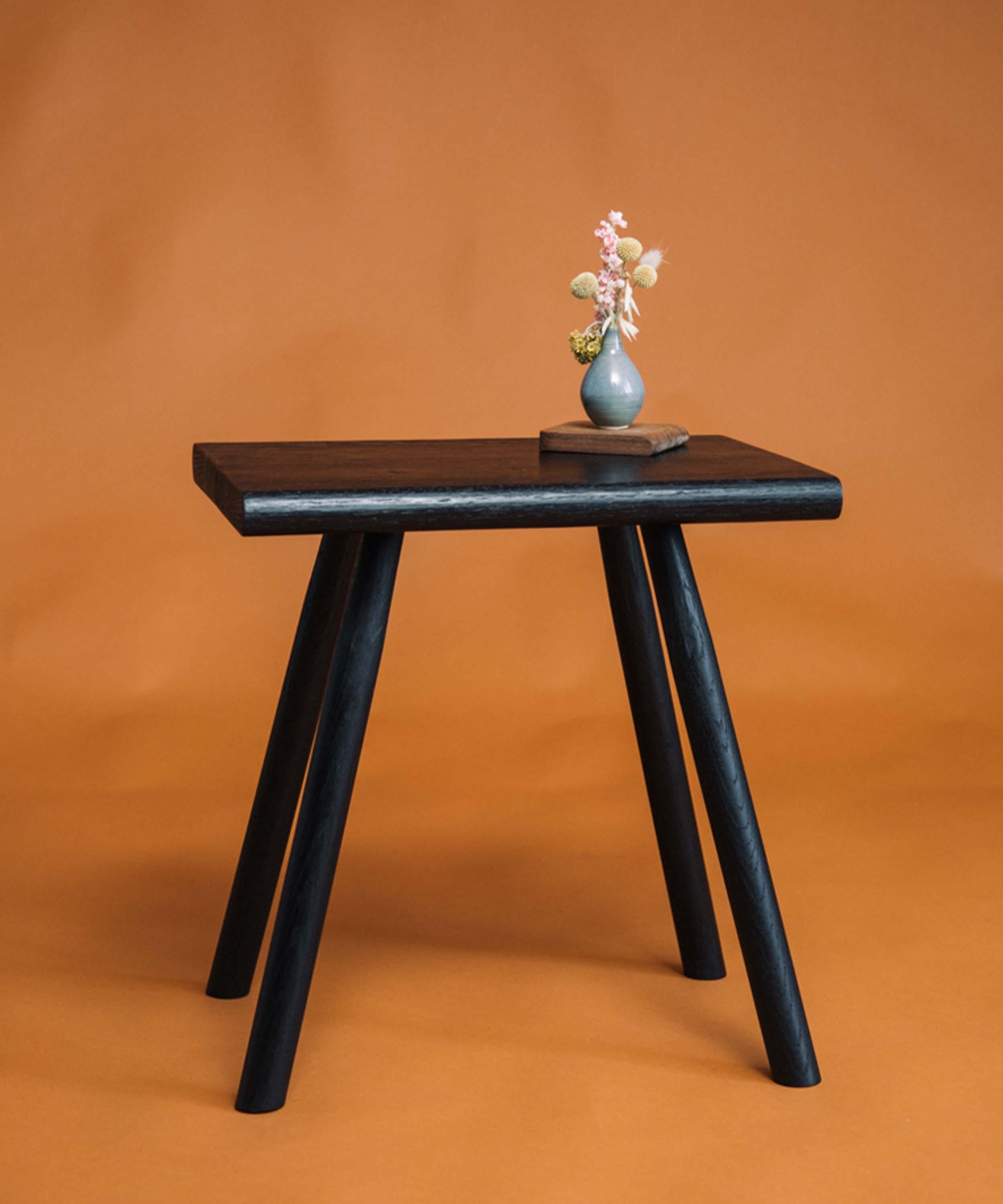 This hand crafted wood stool and side table made of English Oak and dyed black is perfect for use in any room, from bedside table to living room seating.
It is large enough to comfortably sit on, whilst also being perfect to work next to a sofa, to
