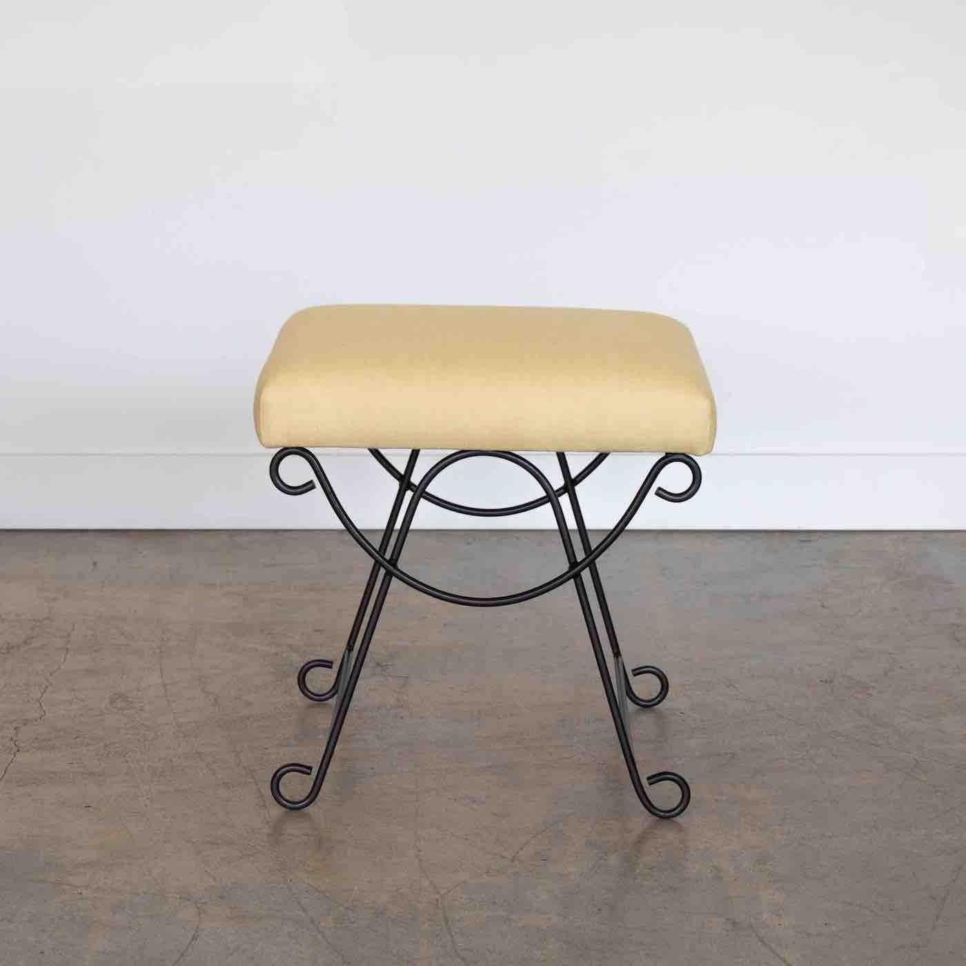 Beautiful iron stool with curved and looped base painted in a matte black finish. Rectangular cushioned seat upholstered in a yellow linen or can be COM. 