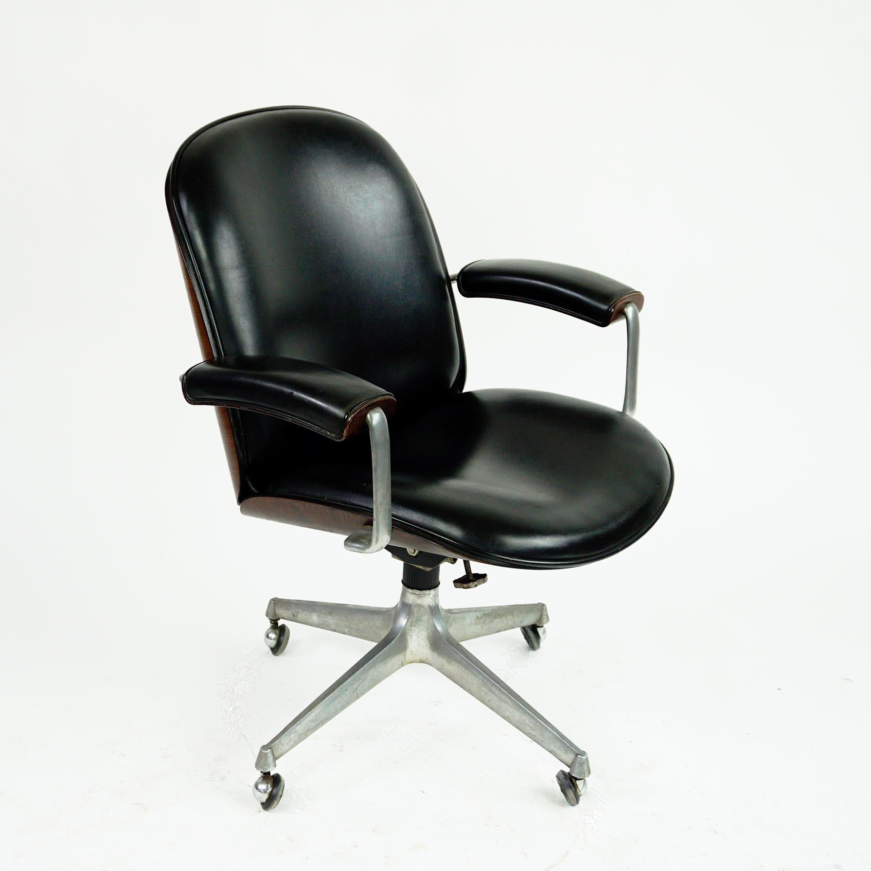 This Iconic Italian 1950s swivelling office chair on wheels from the Terni Series was designed by Ico Parisi for MIM Roma . Mobili Italiani Moderni- 1959.
It features a four star cast aluminum base, rosewood veneer and original black leatherette