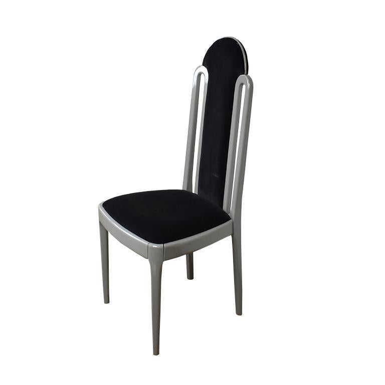 A lovely Art Deco style dining chair, made in Italy. The chair features a tall rounded back upholstered in a lush black velvet. On either side of the back, small metal rounded details frame the upholstered portion. 

The square metal seat is