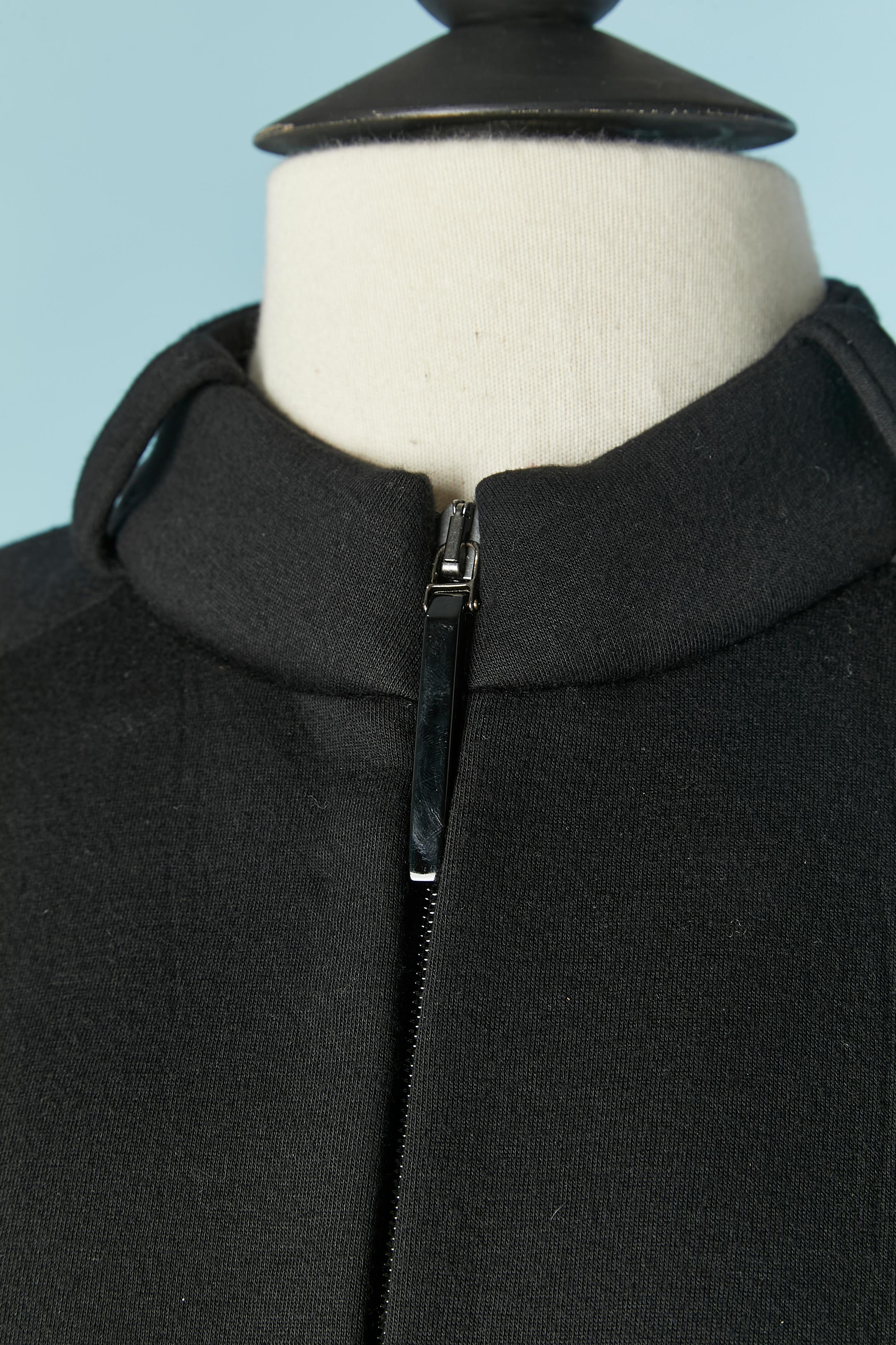 Veste noire avec ceinture. Composition du tissu : 100% rayonne 
Manches raglan. Fermeture zippée sur le milieu du devant avec ceinture, passant de ceinture et boucle. Le col est également pourvu d'un passant pour ceinture. Ceinture avec boucle sur