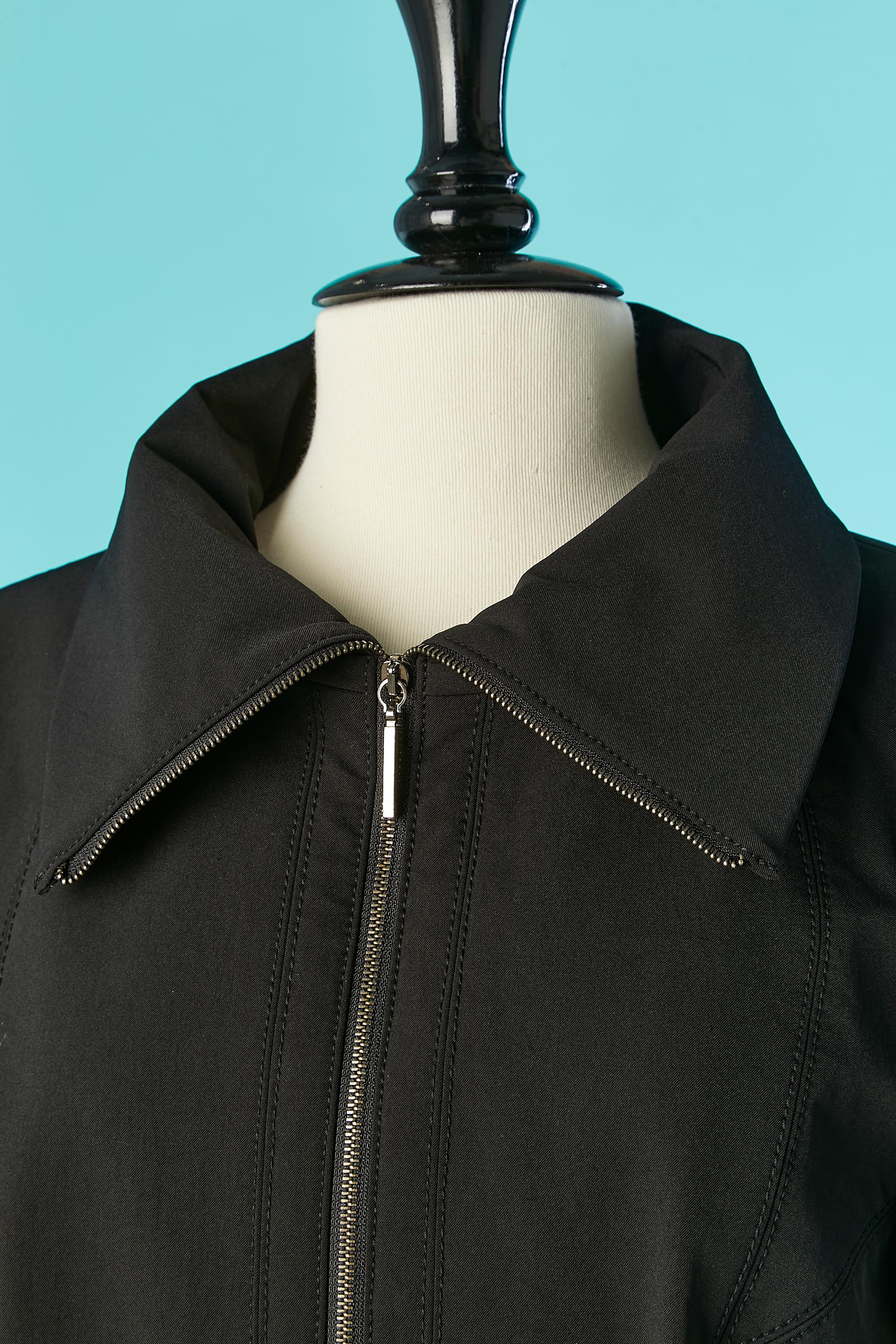 Schwarze Jacke mit Nerzstreifen an den Ärmeln. Reißverschluss in der Mitte der Vorderseite mit Marken-Reißverschlussschiebern. Tasche auf beiden Seiten. 
Kein Stoffetikett, aber technischer, wasserdichter Stoff. Durchgeschnitten und abgesteppt.