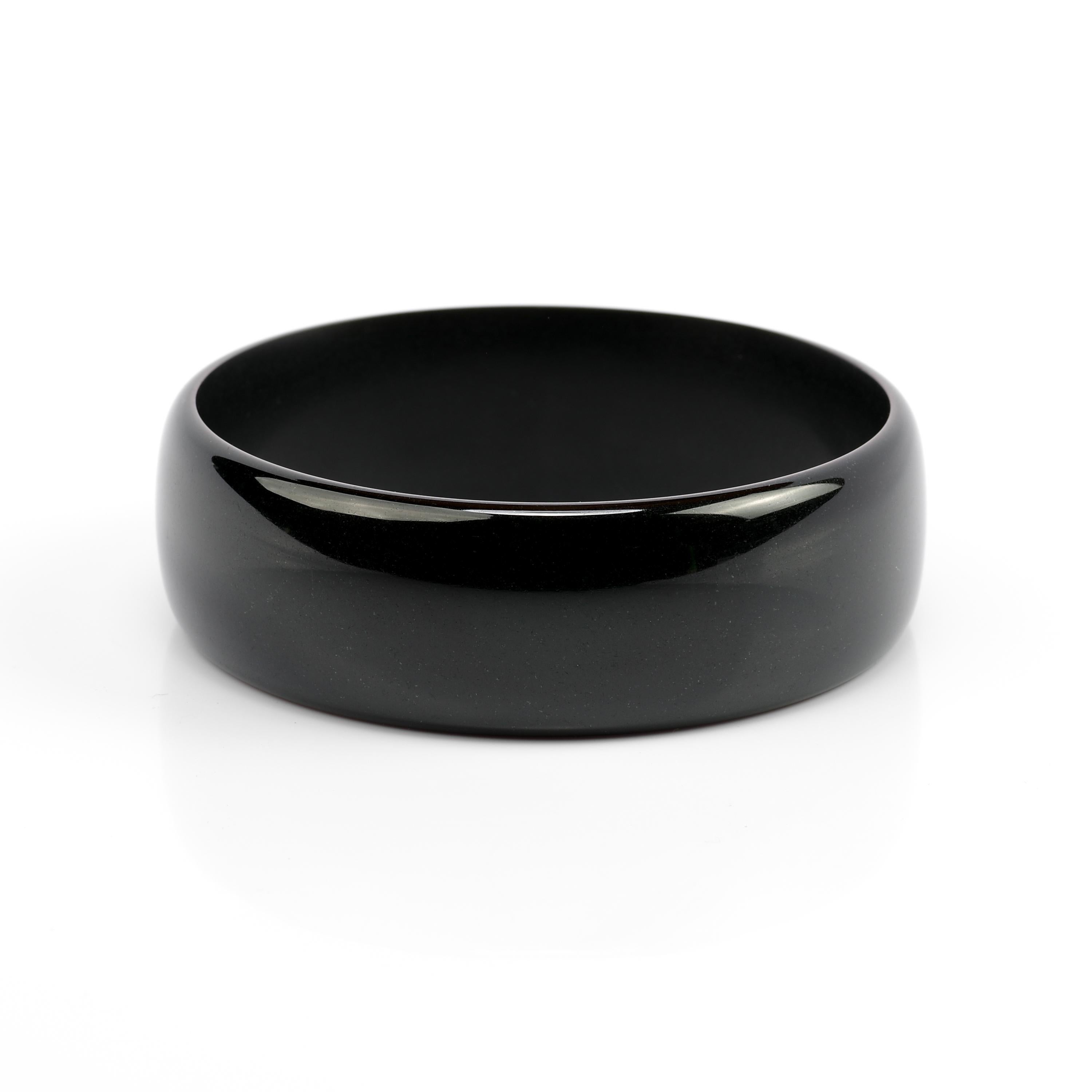 The polish on this inky-black jade bangle is so high, it appears to be spinning. Bring it near a window; you will see a perfect reflection of the window and everything outside of it. But the interior of the bangle is not high-polish; rather it has