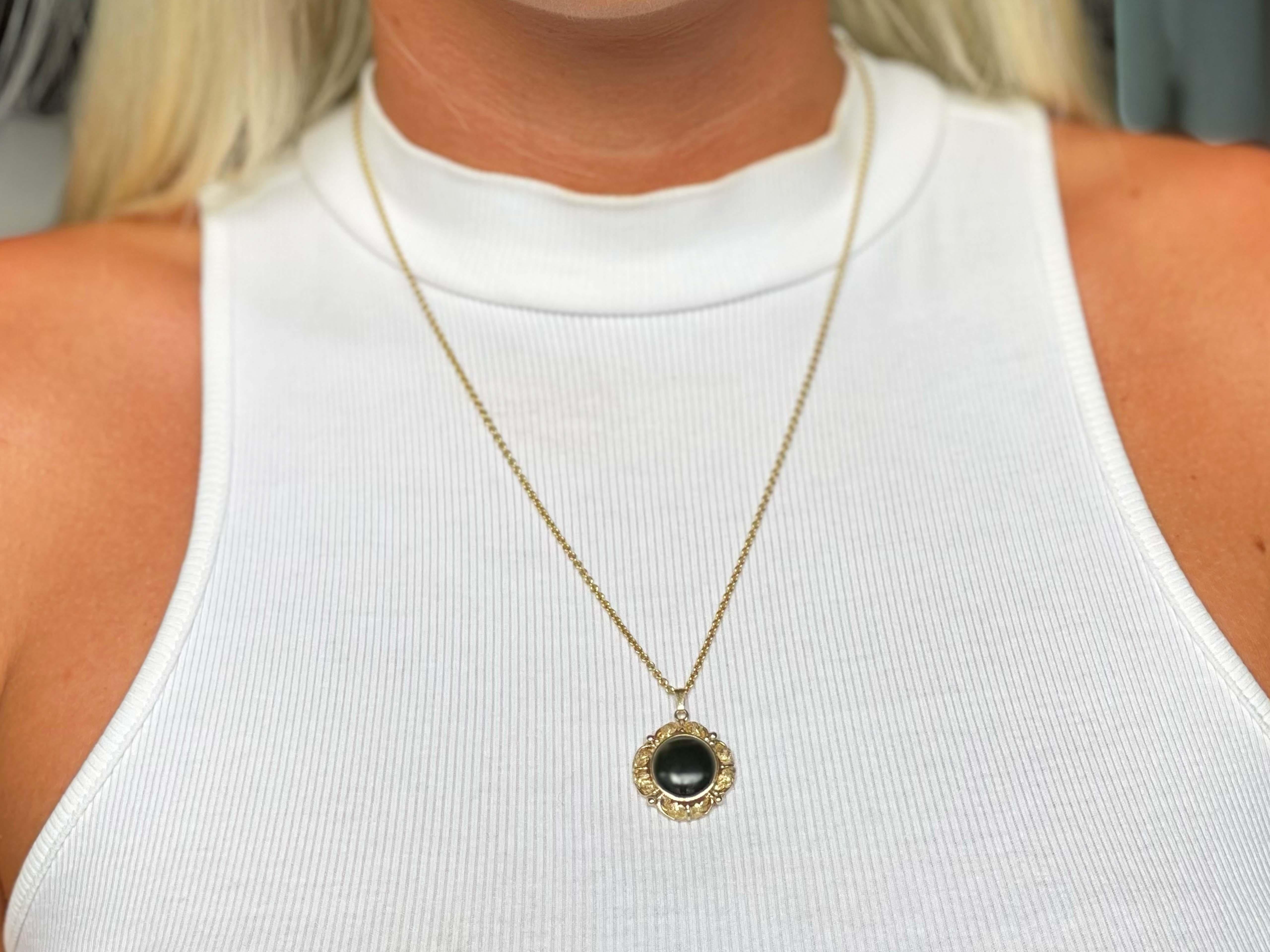 Black Jade Pendant in 14k Yellow Gold. The jade is bezel set surrounded by a botanical leaf design. Stamped 