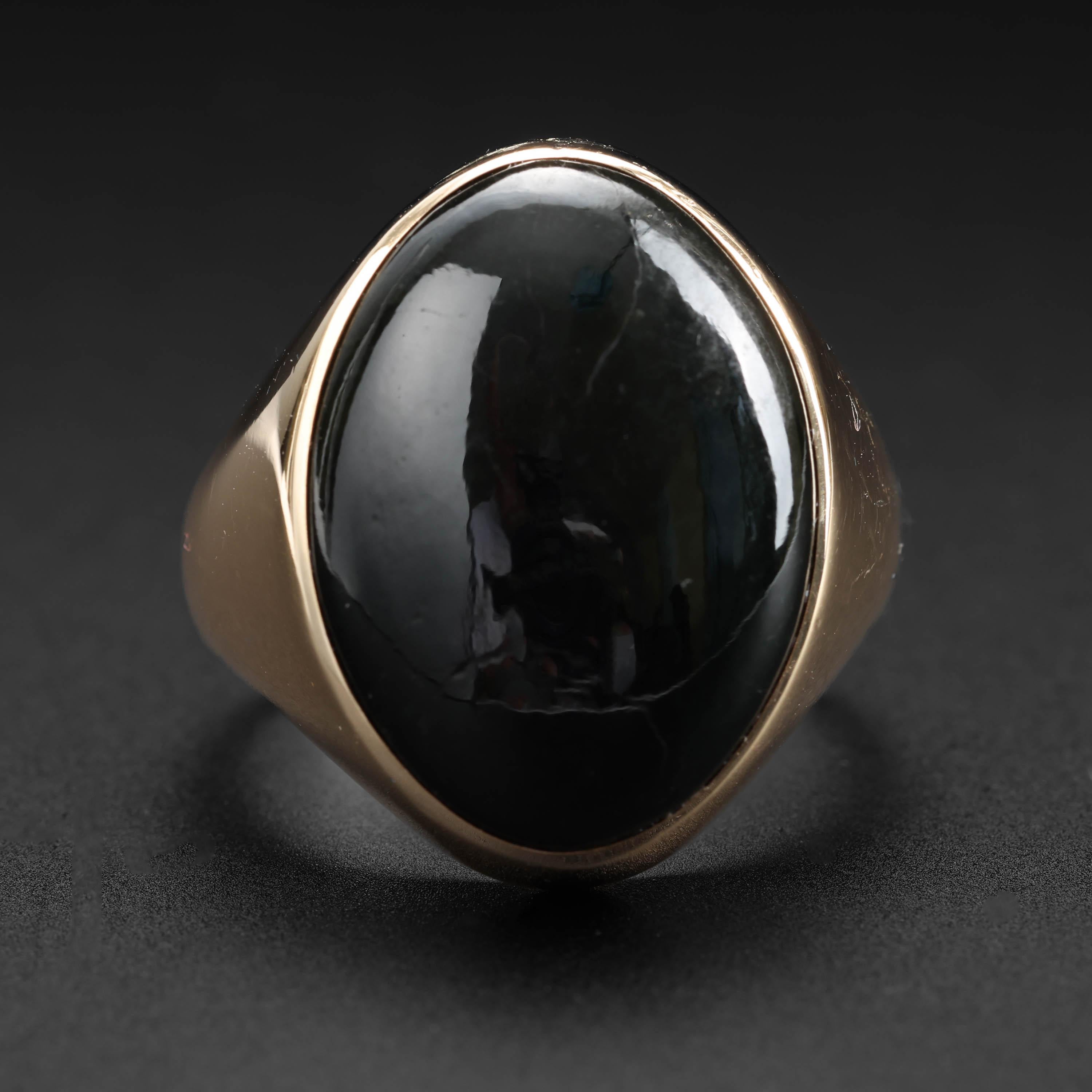 This classic midcentury (circa 1960s-1970s) black jade ring features a cabochon of unique jade: half omphacite jade; half jadeite jade. The glossy piano-black natural and untreated jade stone is both bold and understated at the same time. The iconic