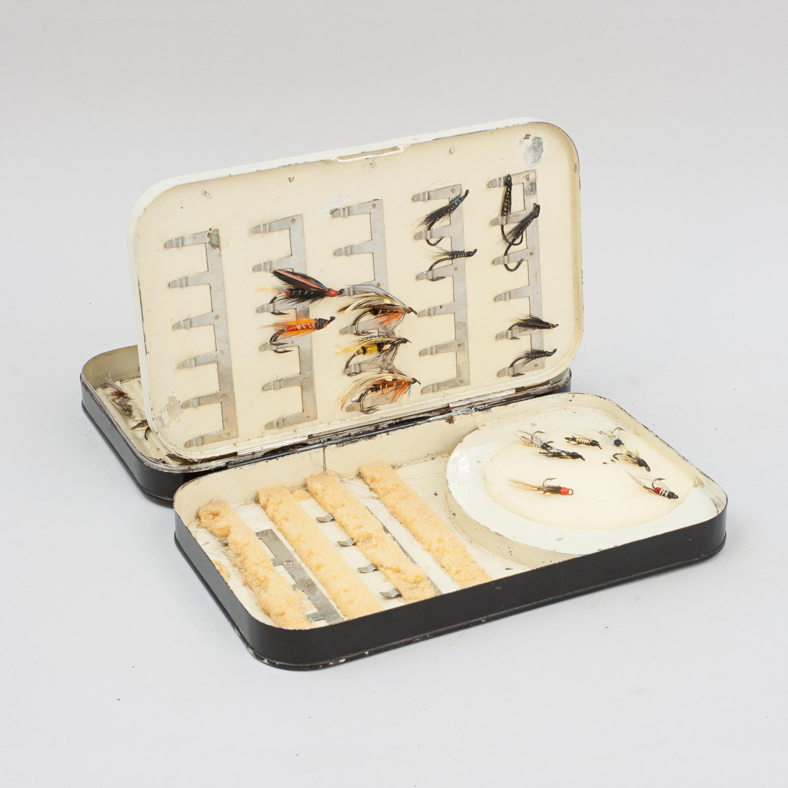 Malloch's Japanned Fly Tin.
Una buona scatola per mosche a foglia oscillante, con vernice japanned nera, di Malloch di Perth. L'interno color crema di questa scatola per mosche è composto da 4 pannelli e da uno scomparto per il lancio. Due delle