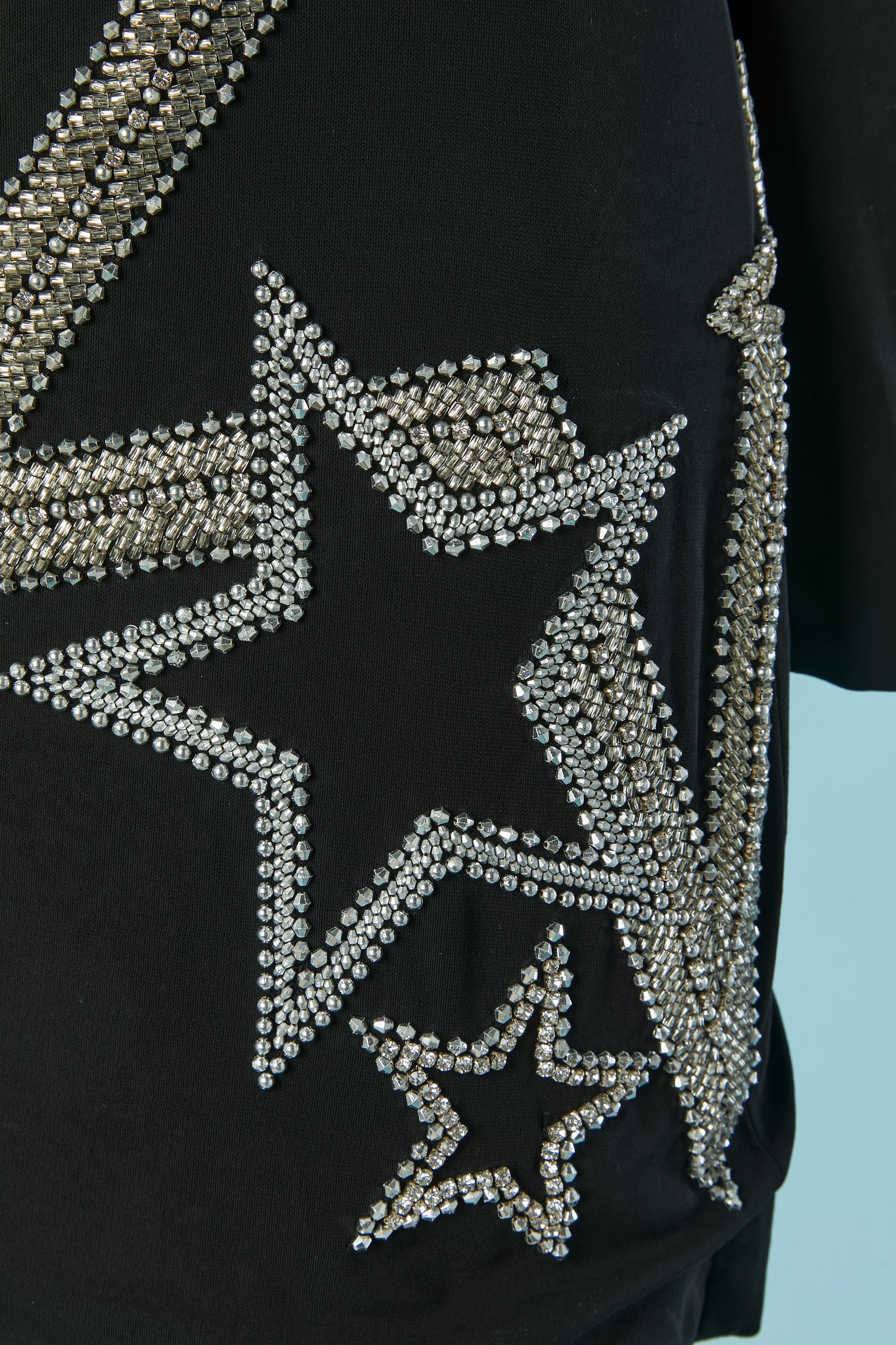 Robe de cocktail en jersey noir avec perlage (strass et perles de verre) Composition du tissu principal : 95% rayonne, 5% élasthanne. Doublure en rayonne. Fermeture à glissière en métal doré au milieu du dos + fermeture à glissière invisible sur le