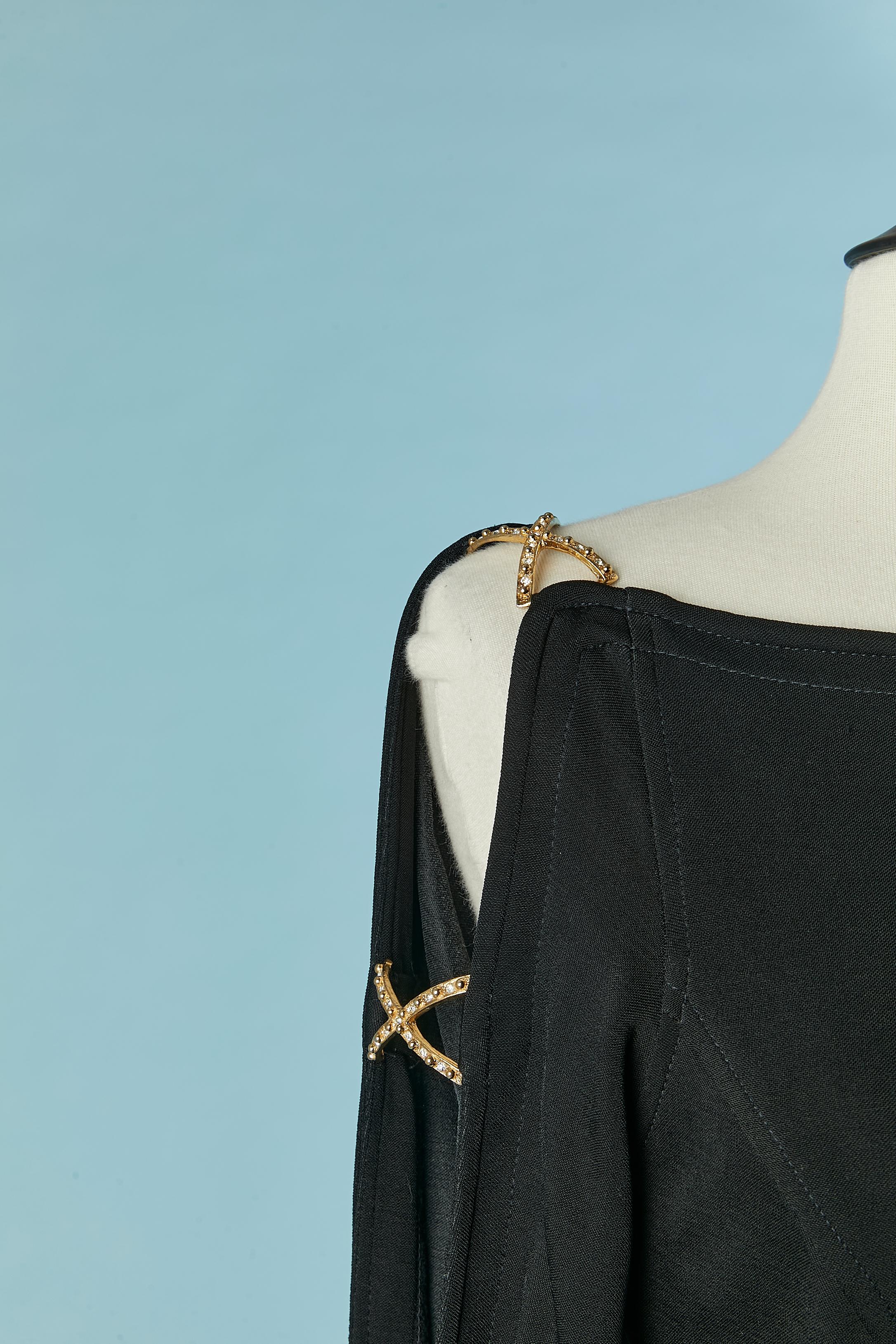 Abito da sera in jersey nero con abbellimento di strass sulla manica. Non c'è l'etichetta della composizione del tessuto, ma si tratta di jersey elasticizzato. Croci in metallo dorato con strass sulla manica aperta. Spaccato sul lato: 60 cm
Chiusura
