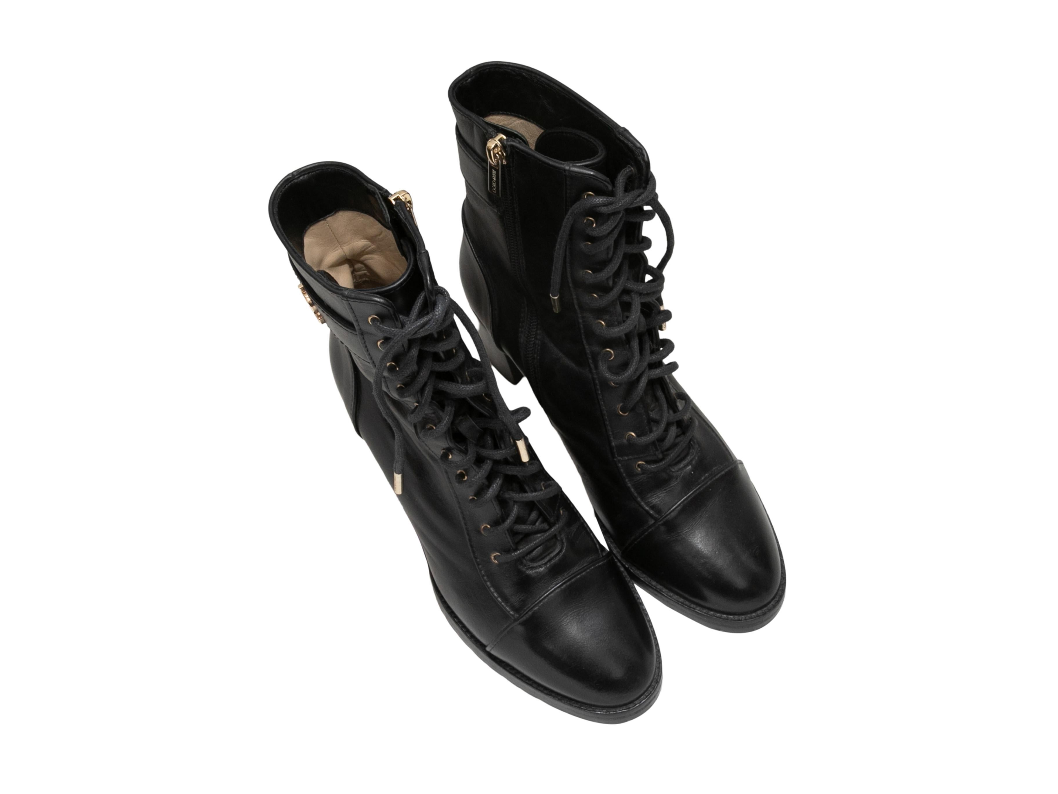 Black leather lace-up heeled ankle boots by Jimmy Choo. Gold-tone hardware. Stacked heels. Lace-up detailing at tops. Zip closures at inner sides. 6