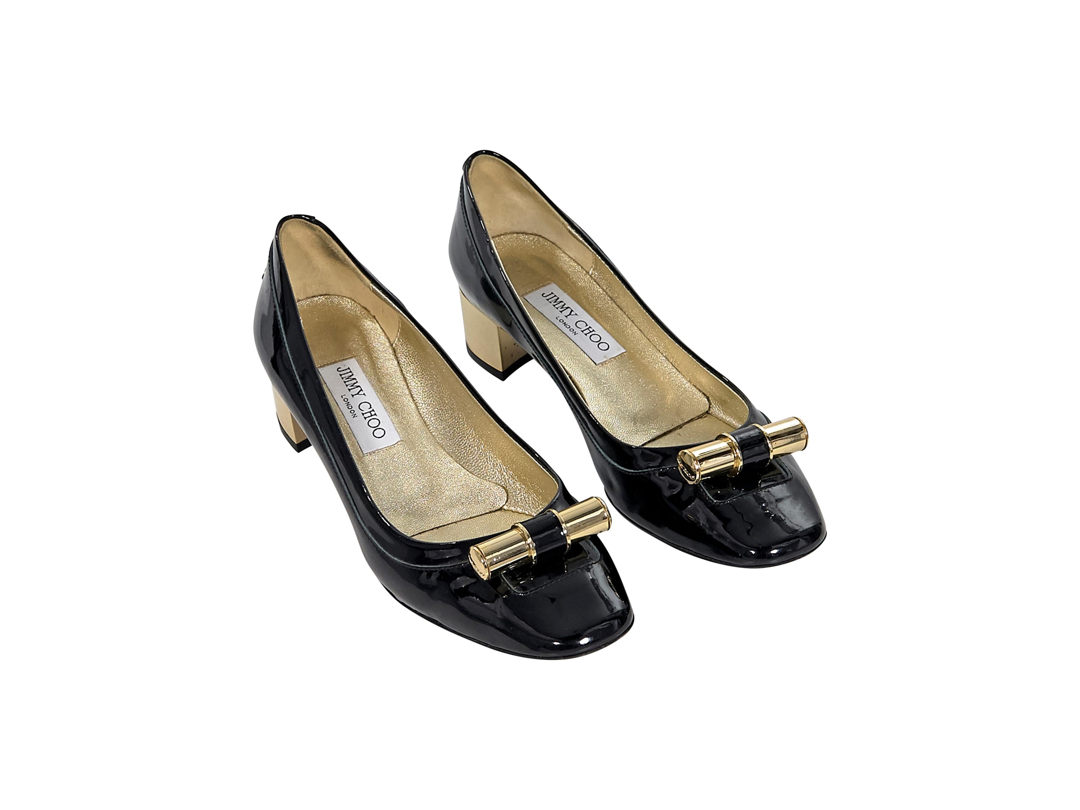 Product details:  Black patent leather kitten heels by Jimmy Choo.  Metal detail accents vamp.  Rounded square toe.  Slip-on style.  Goldtone hardware.  1.75