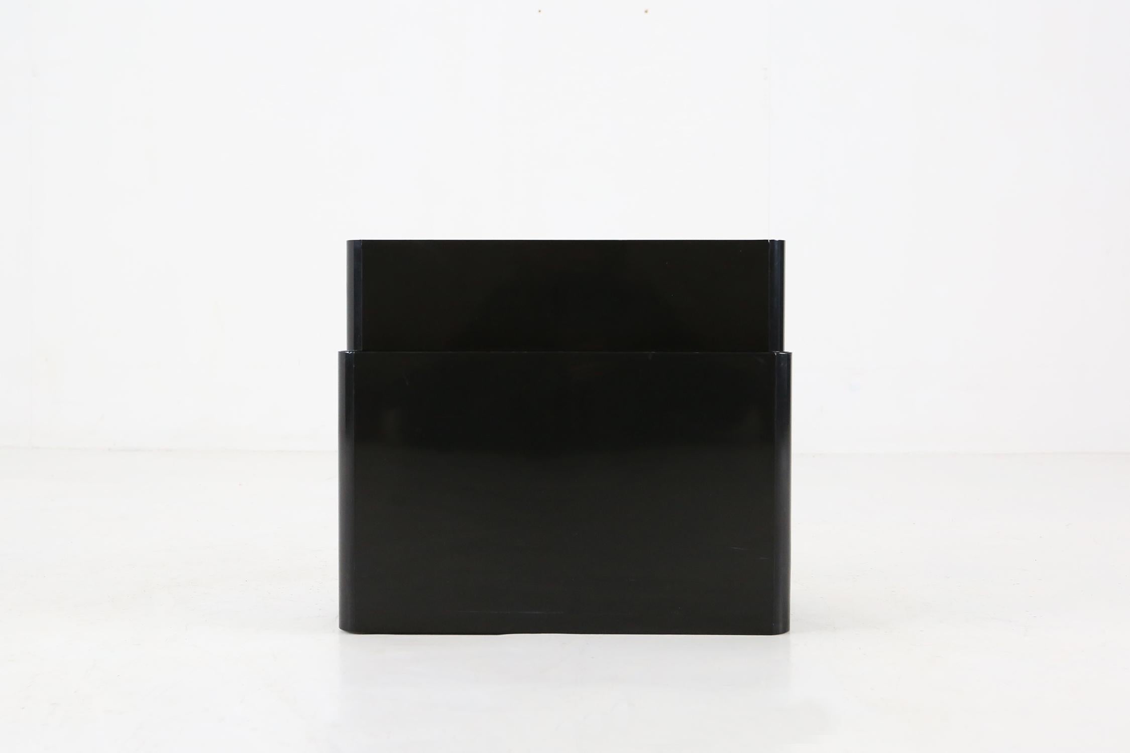 Magazine rack by Kartell, design Giotto Stoppino. A minimalist magazine rack made of black plastic from the 1970s. Center includes a handy carrying handle.