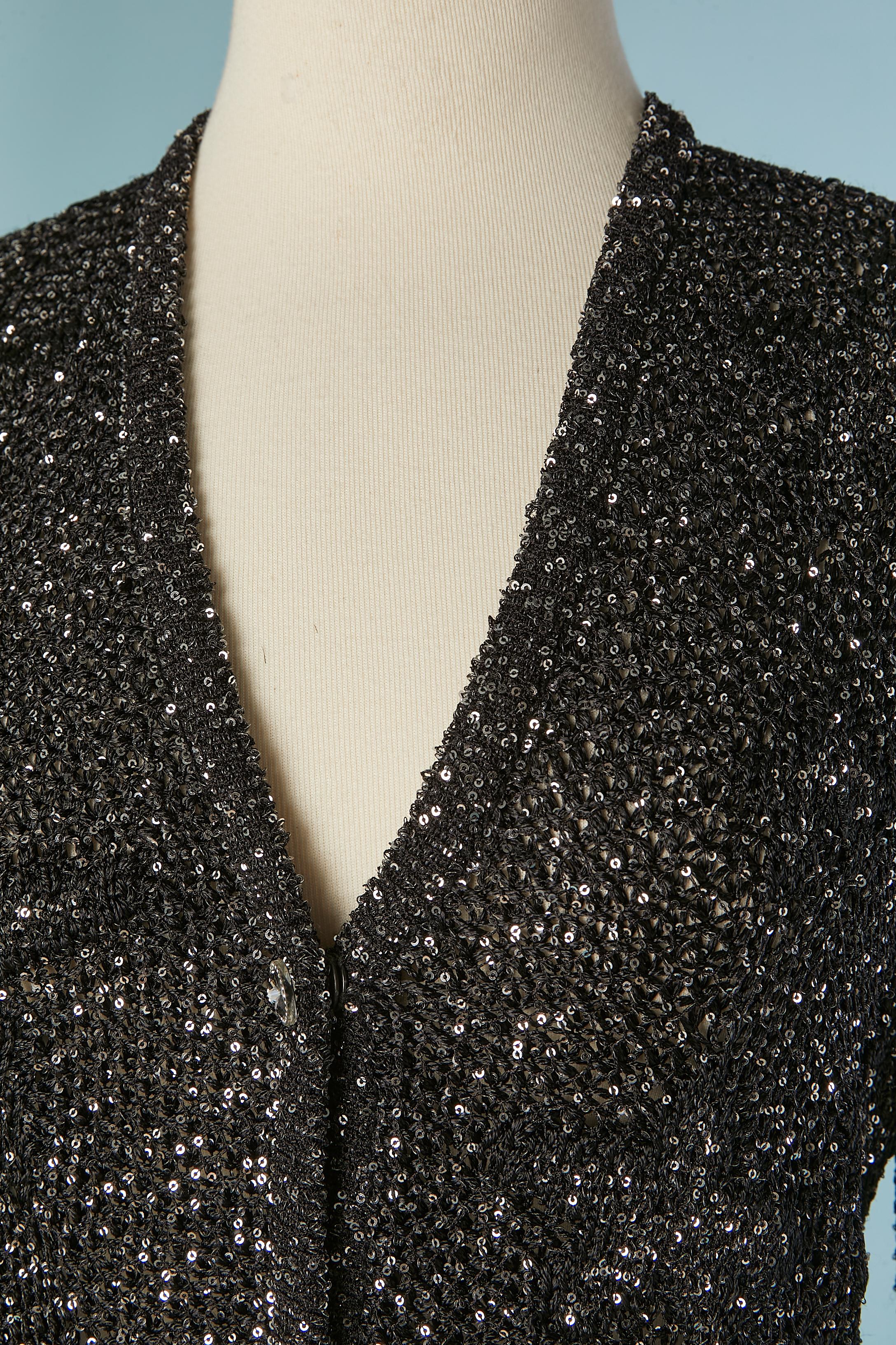 Abito con gonna in maglia nera e paillettes argento con motivo jacquard a stelle. Composizione della maglia: 54% rayon, 25% nylon, 21% poliestere. Composizione della fodera della tasca: 100% nylon. 
Bottone decorativo con marchio sul centro della