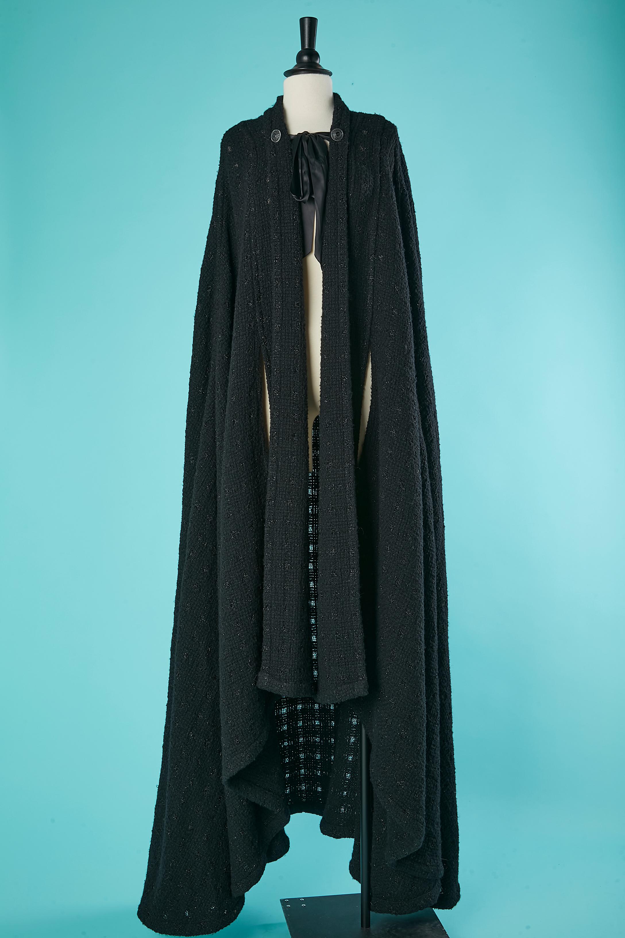 Black knit cape with black ribbon satin bow on the top front and 2 decoratives buttons . Split for the hands on both side. Middle front lenght: 120 cm 
Side and back lenght: 160 cm 
FW 2019/2020
Last Chanel's Show designed by Karl Lagerfeld 
Show