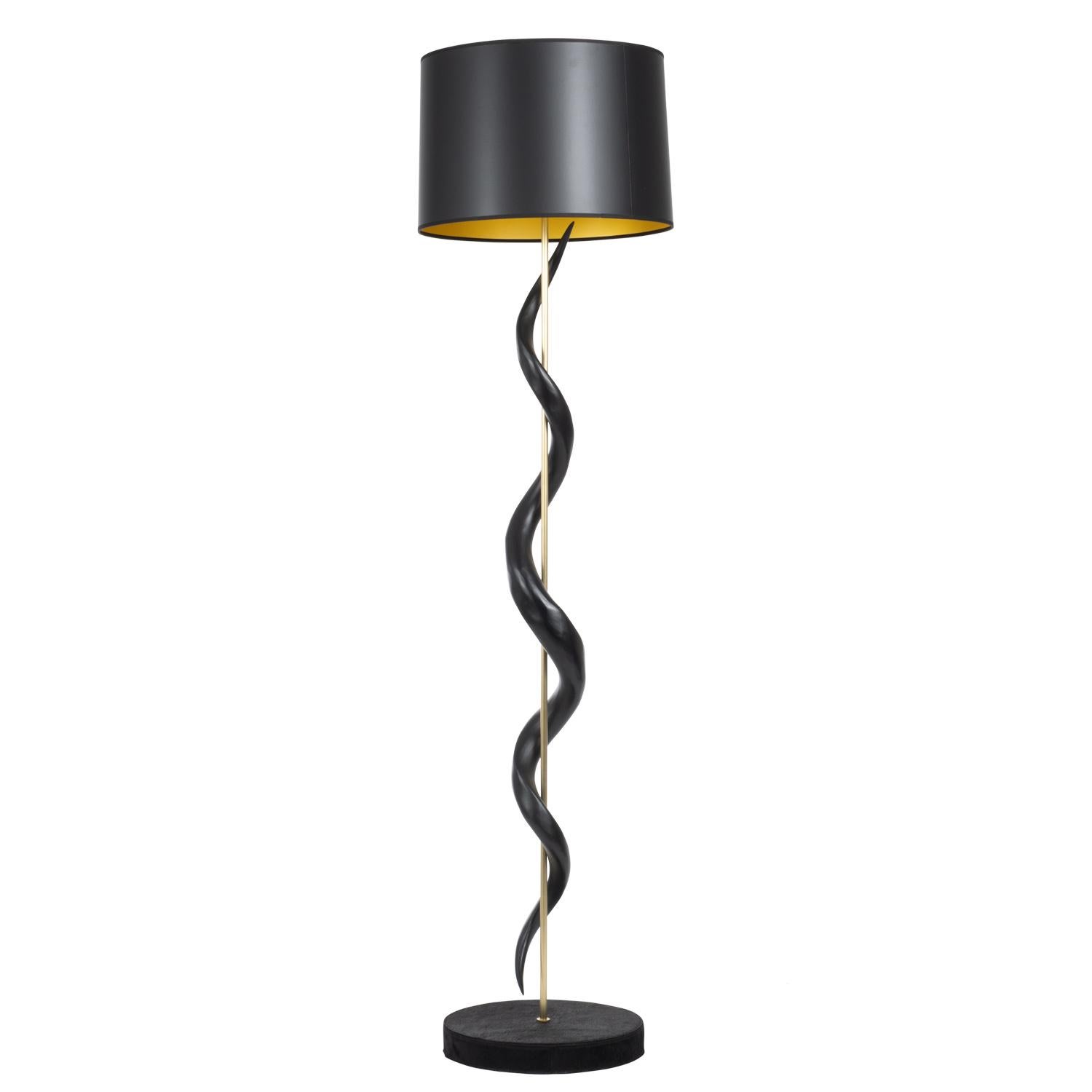 Handcrafted in South Africa, this naturally elegant floor lamp features two inverse African kudu horns encirling a brass rod above a round wooden base, which is wrapped in top-stitched dyed black cow hide. All hide and horn has been sustainably