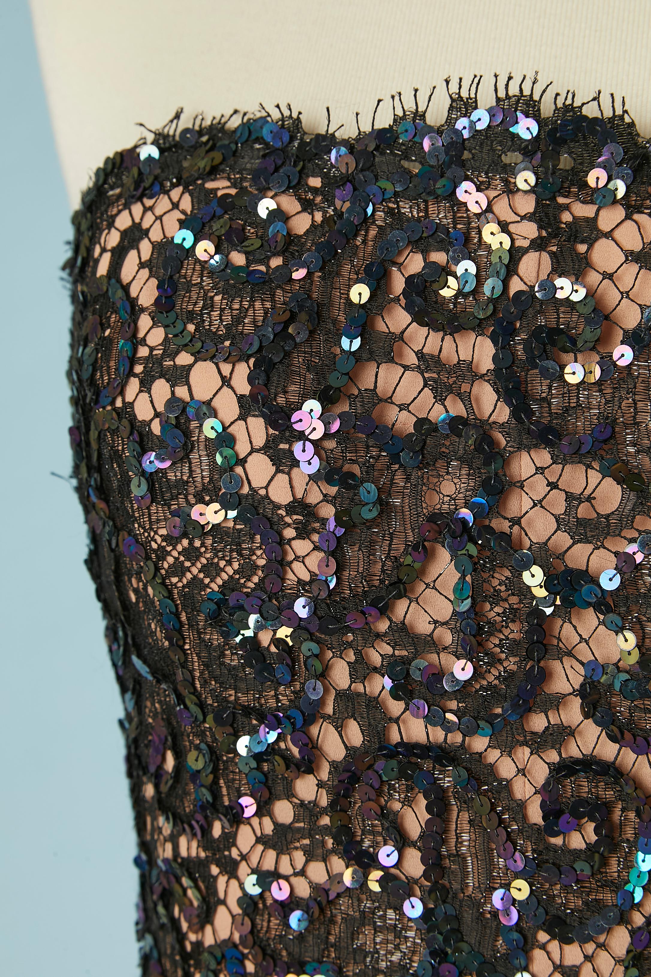 Vestido de noche de encaje negro y faille morado (probablemente rayón) con lazo de terciopelo negro. Forro beige empolvado bajo el encaje. Adorno de lentejuelas en el encaje. Volantes en las caderas. Cierre con cremallera lateral en la espalda y