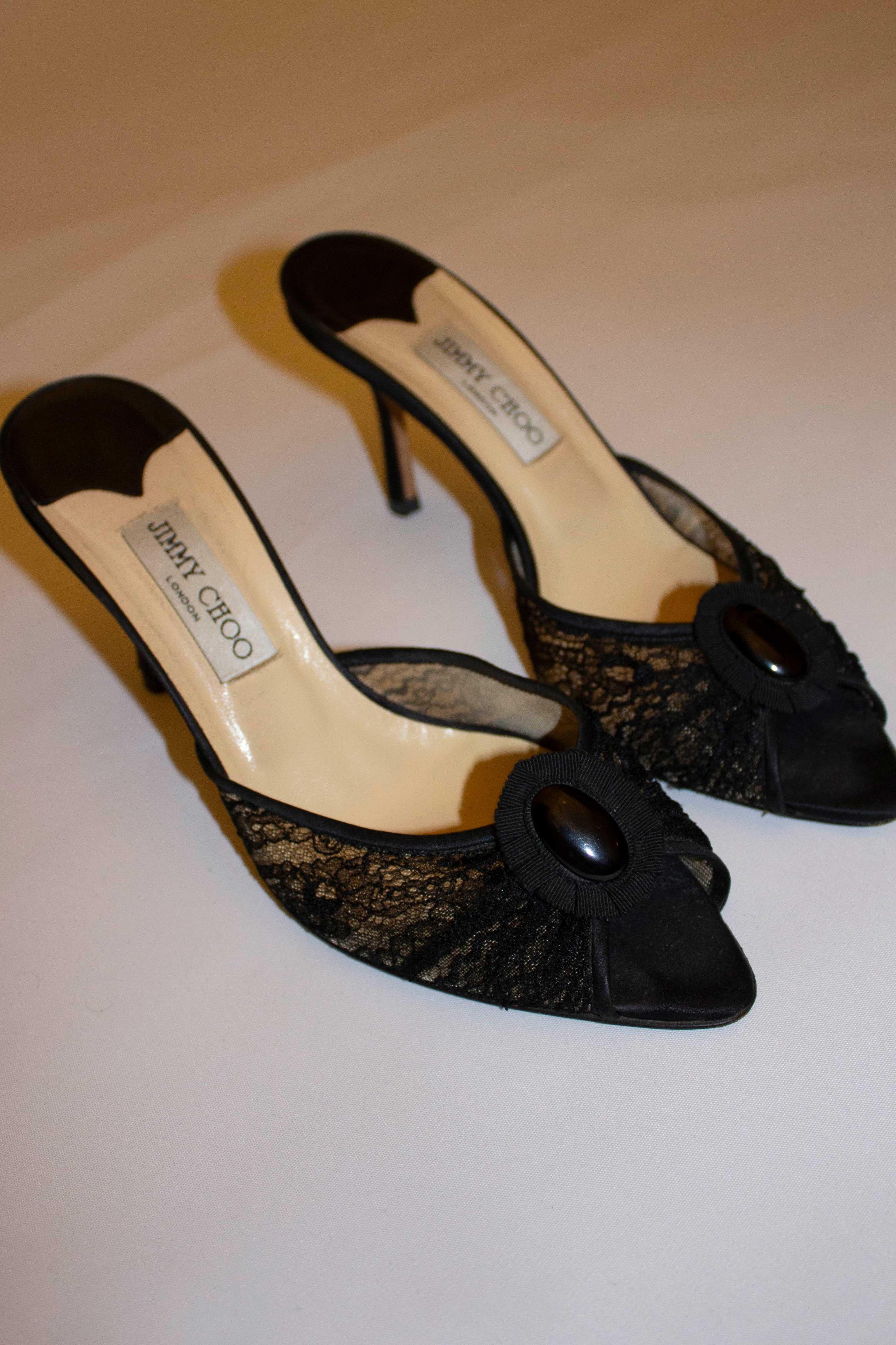 A head turning pair of heels by Jimmy Choo. In black lace with grosgrain detail on the front, the heels are in excellent condition. Heel height 4'' size 39 1/2.