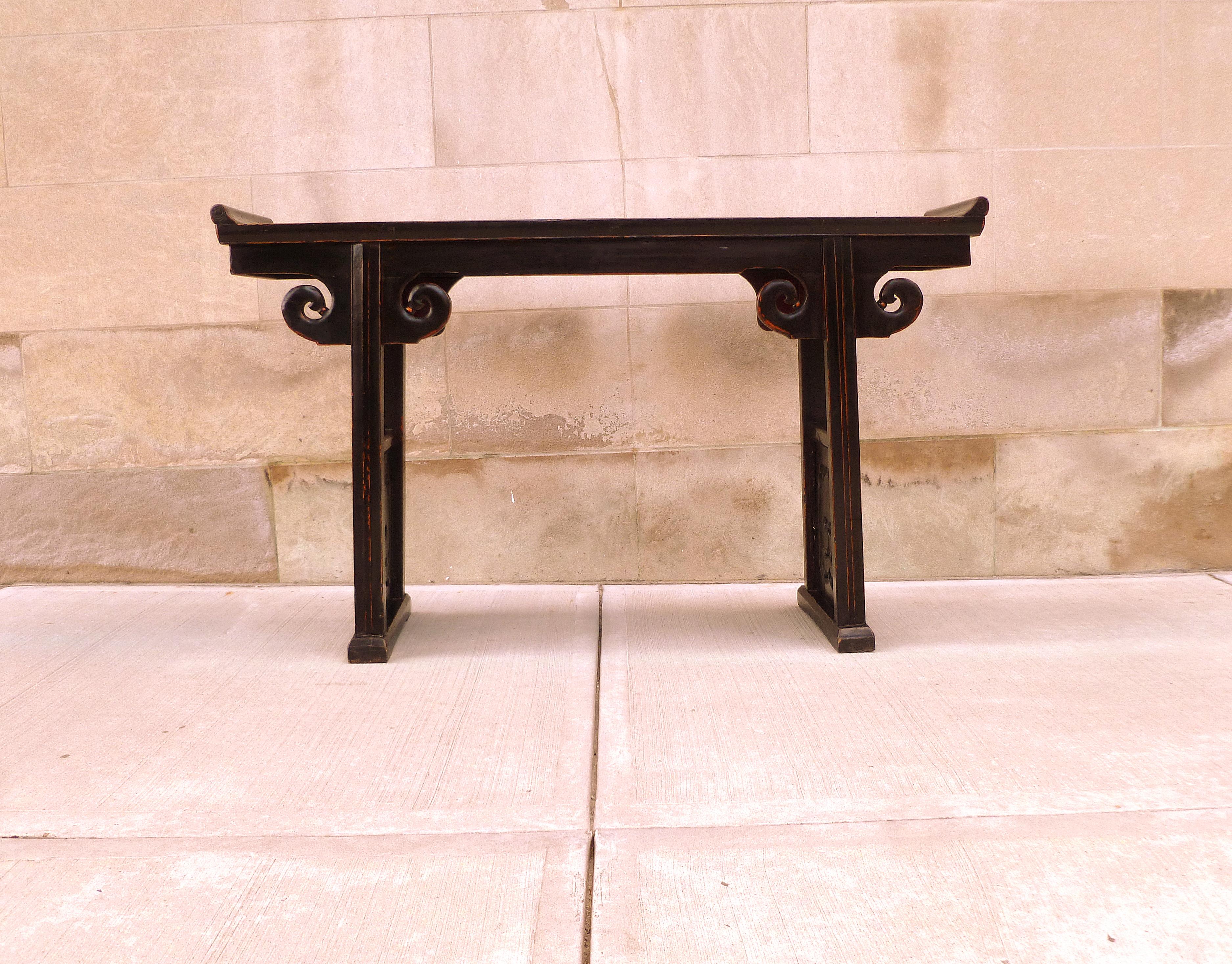 Black lacquer altar table with everted flangers with auspicious design pierce carving side panels.