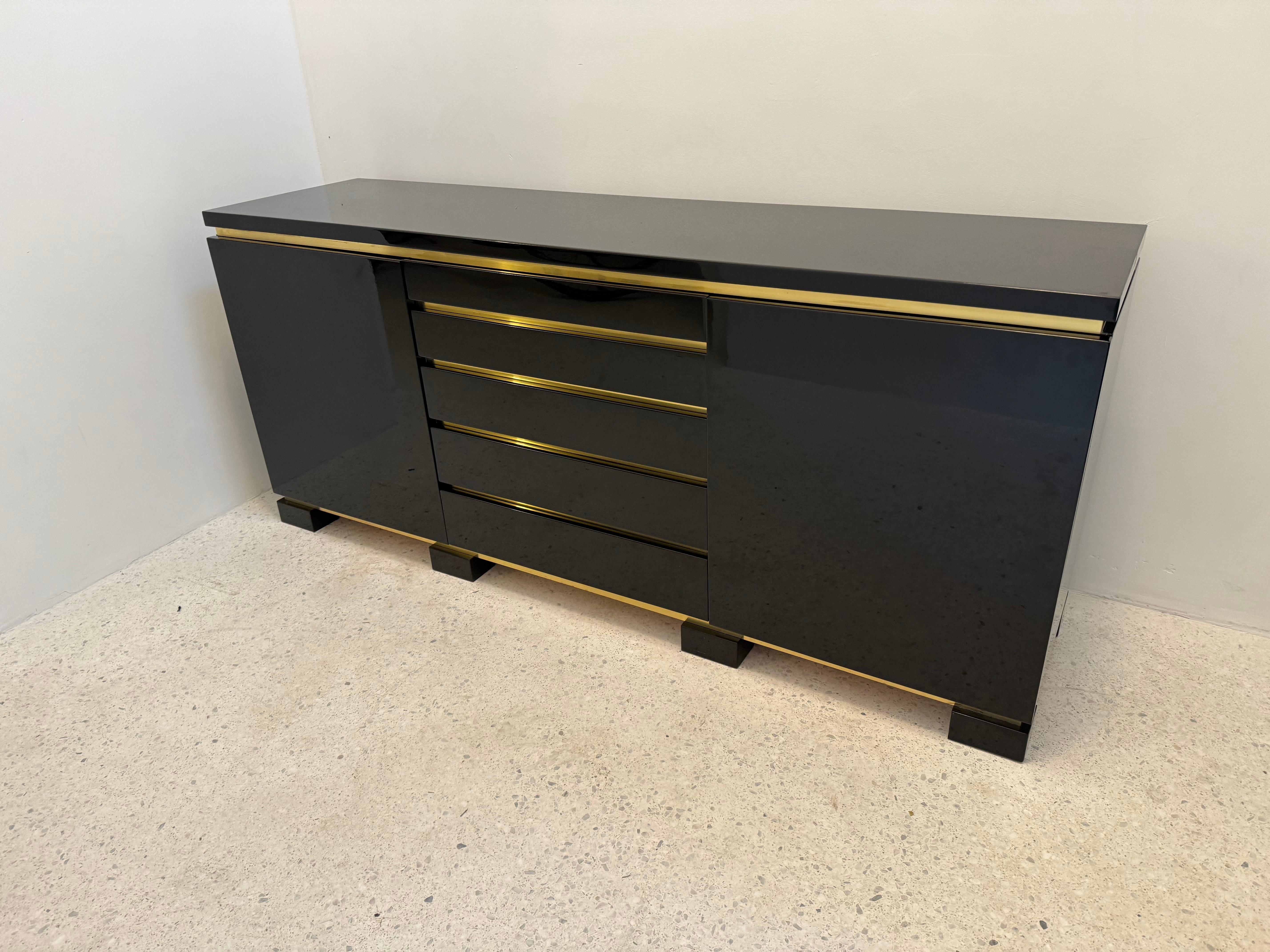 Lacquer and brass buffet in the style of french designer Jean Claude Mahey. The buffet has five middle drawers and opens on either side on shelves. 