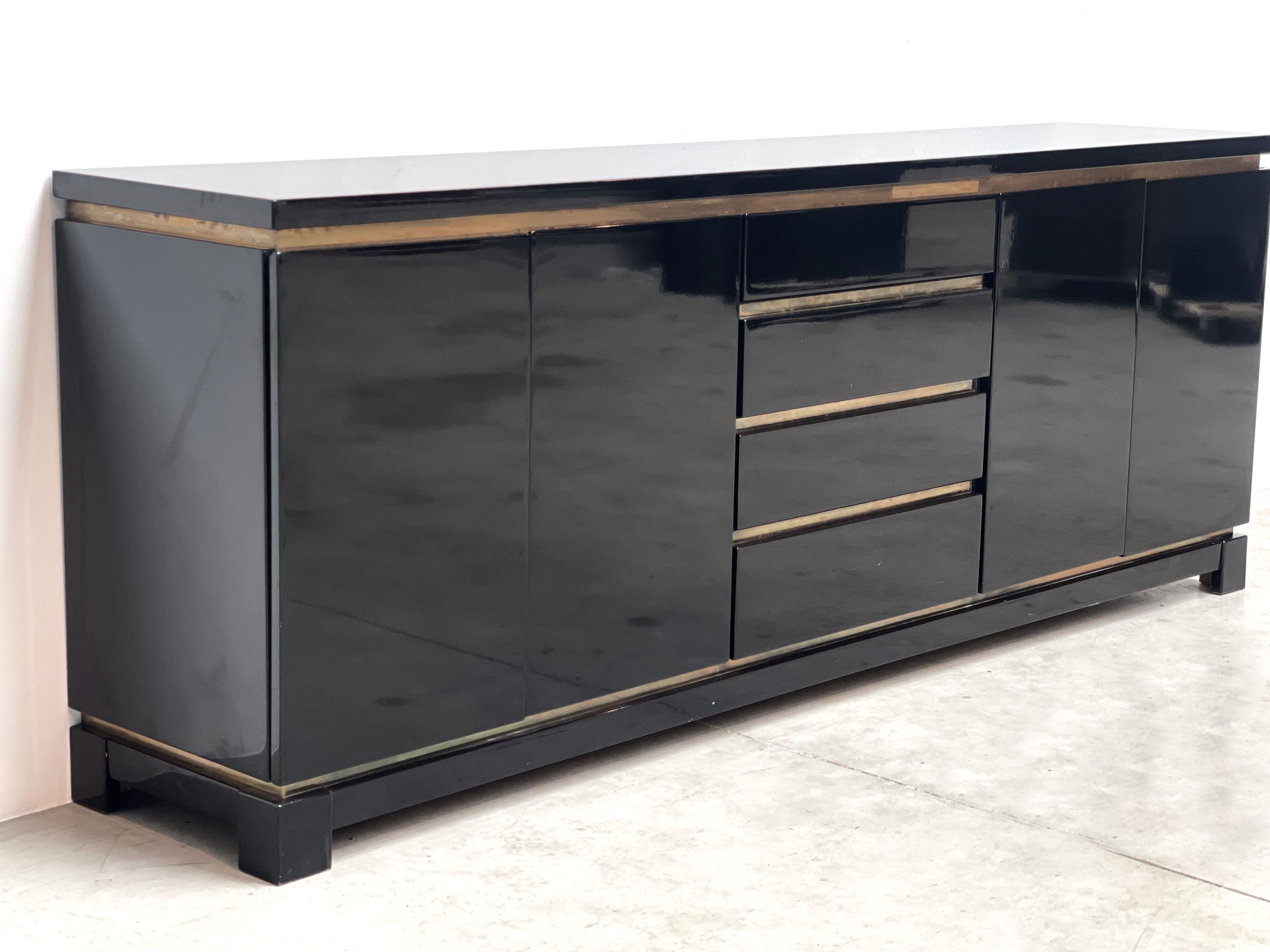 Luxurious seventies glamour sideboard by Jean claude Mahey consitsing of black lacquer panels and brass.

The use of different high quality materials makes this piece very attractive.

The sideboard offers plenty of storage space

Good condition