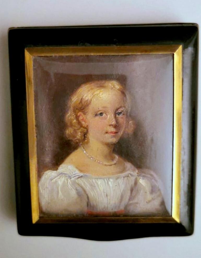Particular and rare box in black lacquer and golden frame; on the lid, protected by a convex glass, is painted in tempera a miniature representing a delicate face of a young woman; inside is the signature of the artist who executed it, it is
