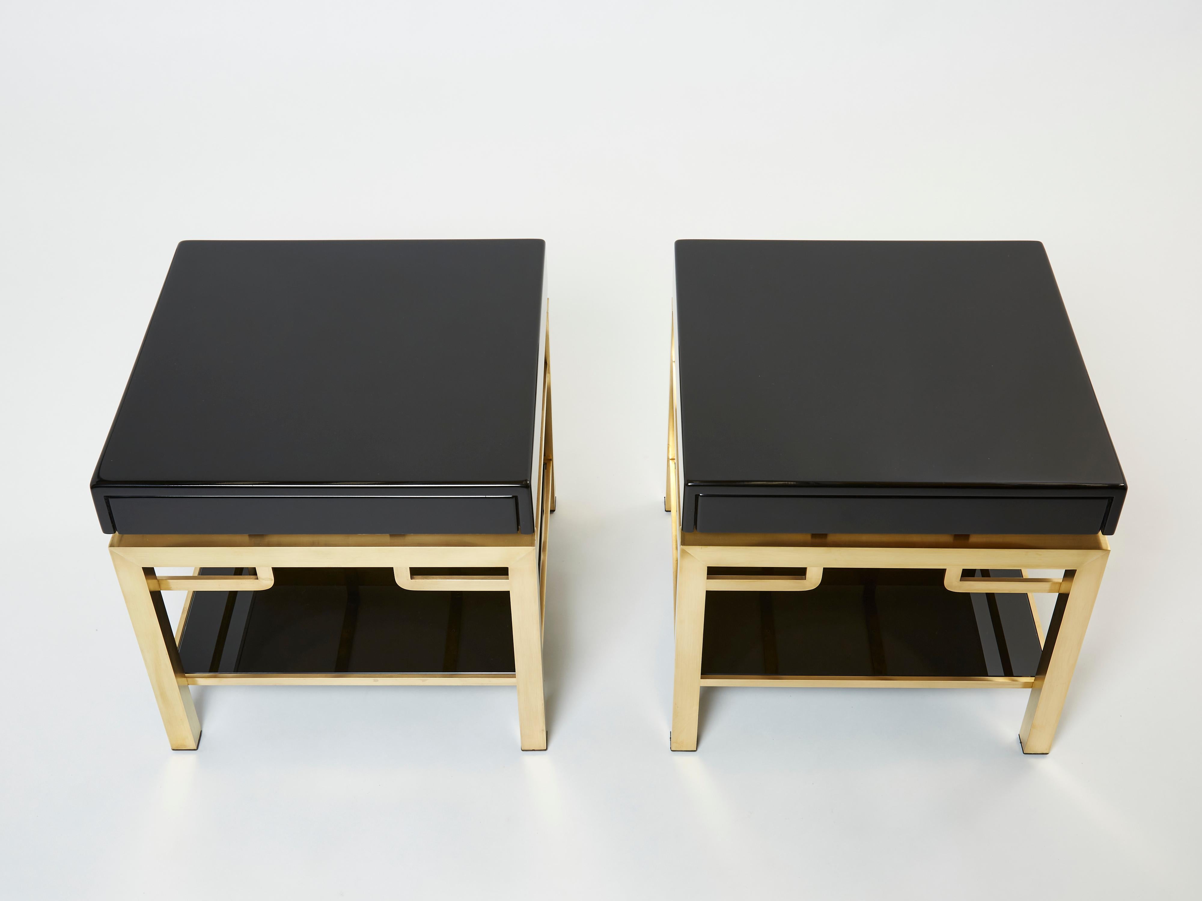 Simple lines point to these two-tier end tables french mid-century roots. Designed by Guy Lefevre for Maison Jansen, it features silky brass legs, with black lacquered top and drawer, with opaline glass shelf under. Its symmetry and strong