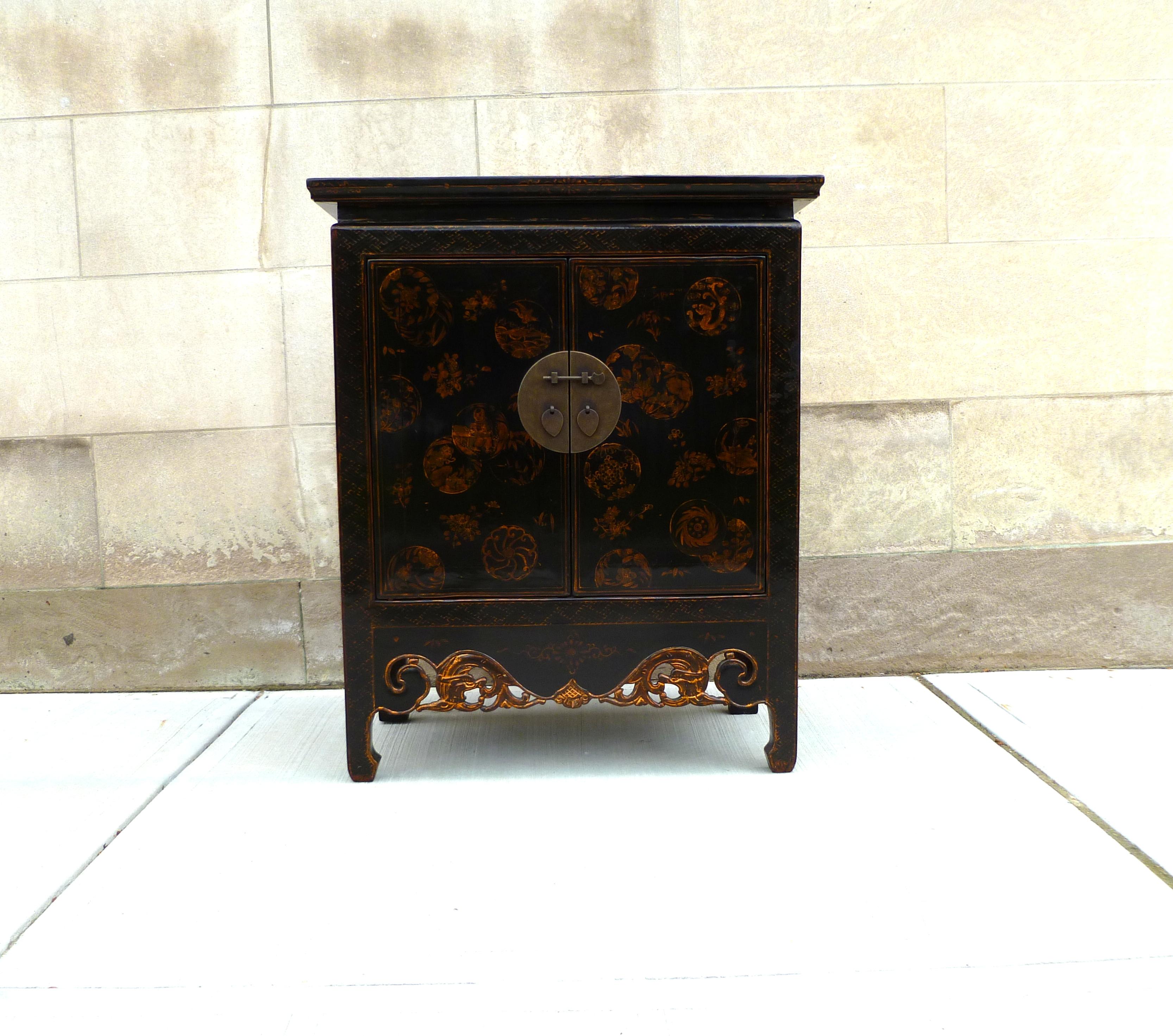Black Lacquer cabinet with gilt motif, pair of doors and shelf inside.