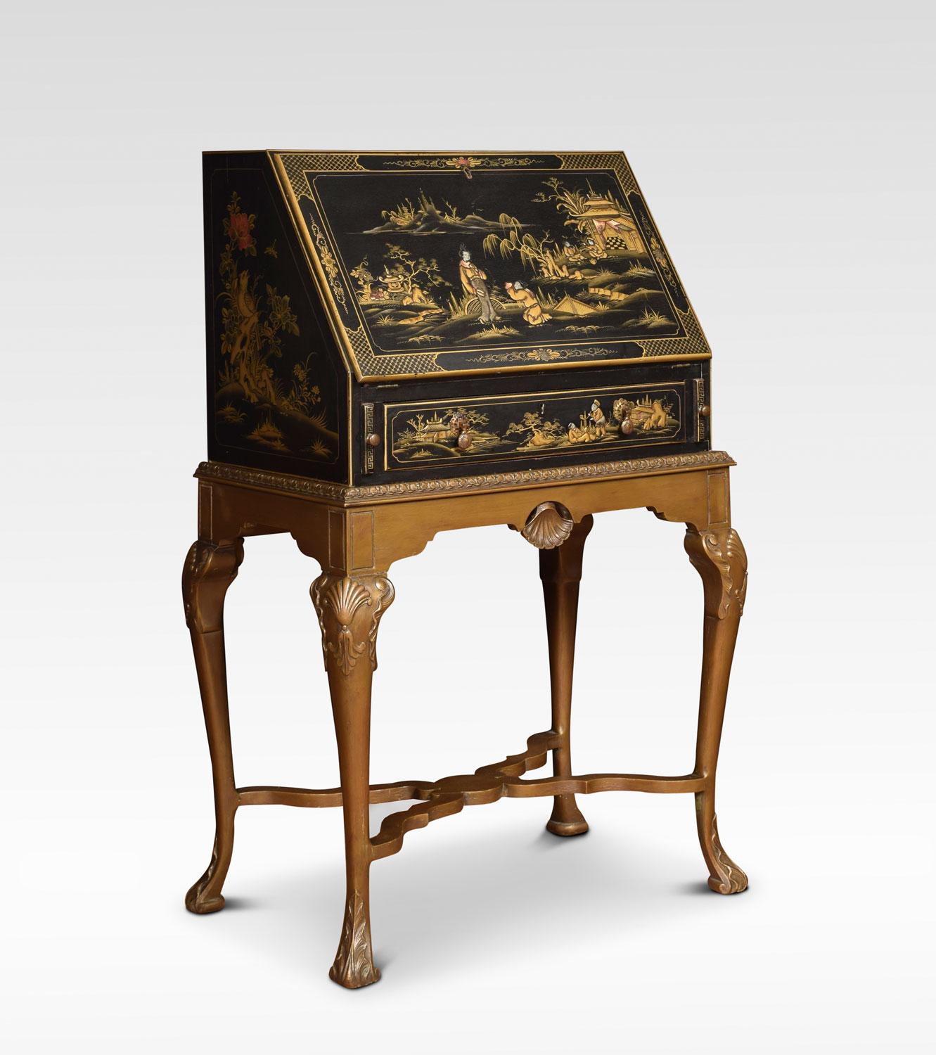 Black lacquer chinoiserie decorated bureau on stand. Painted with typical chinoiserie landscapes within hatched and floral borders. The fall front opening to reveal blue lacquered interior having dragon amidst clouds. The inset tooled leather faux
