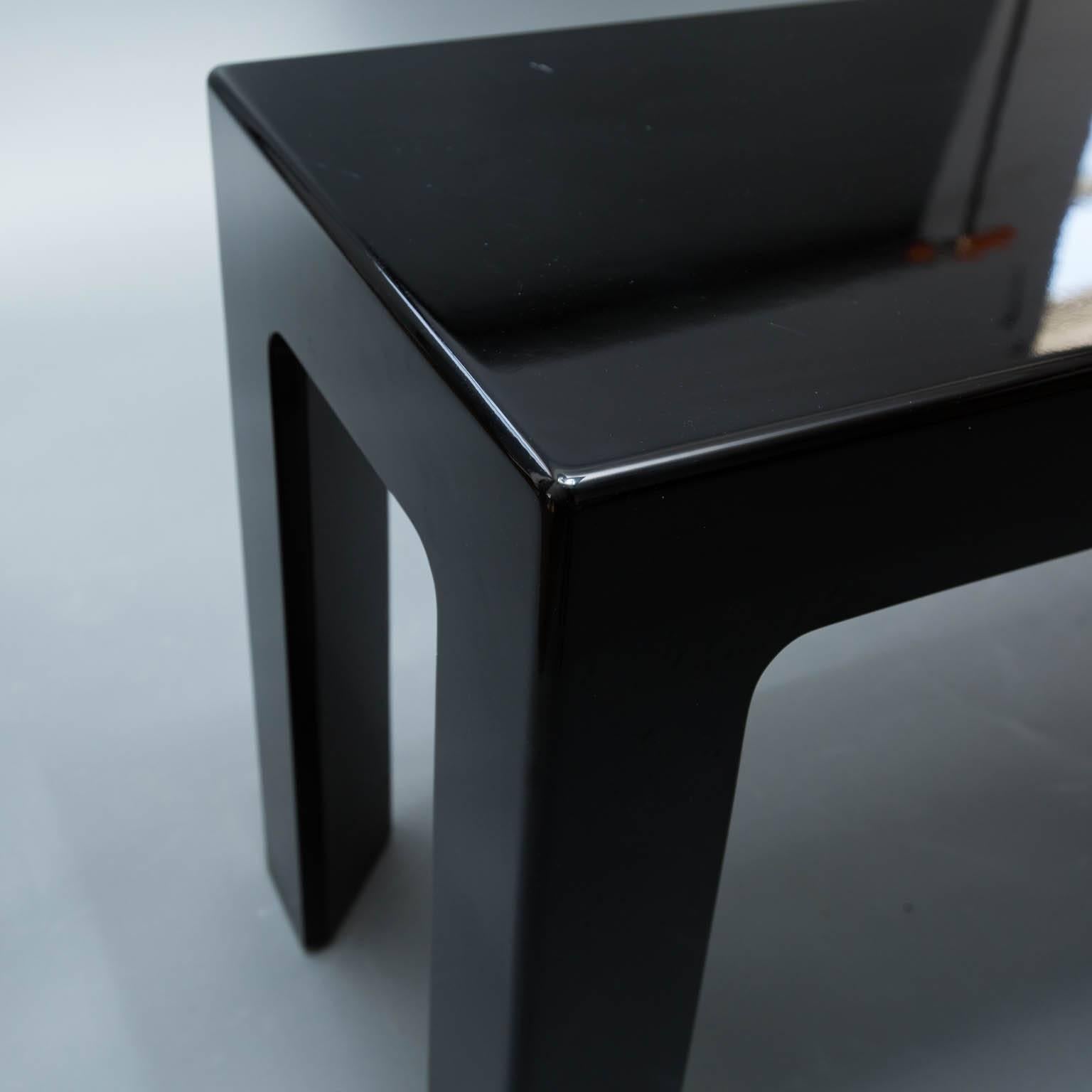 Well-constructed console table with tri-angled legs and an ebony, piano-finished lacquer.