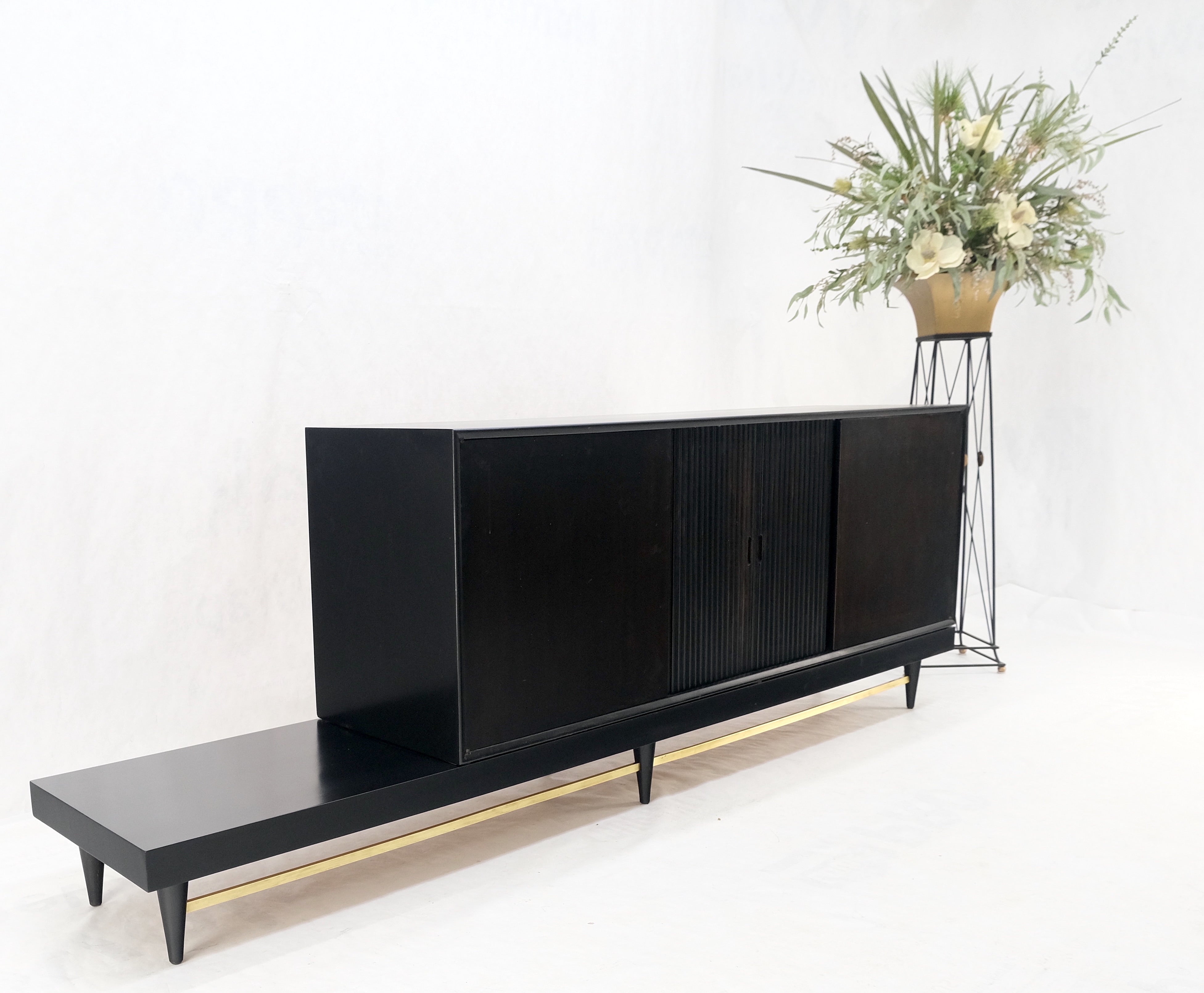Credenza con ante a tamburo in lacca nera ebanizzata del Mid-Century Modern, con cassettiera su piattaforma e barella in ottone MINT!
Si tratta di un mobile diviso in due parti che può essere allestito a 
