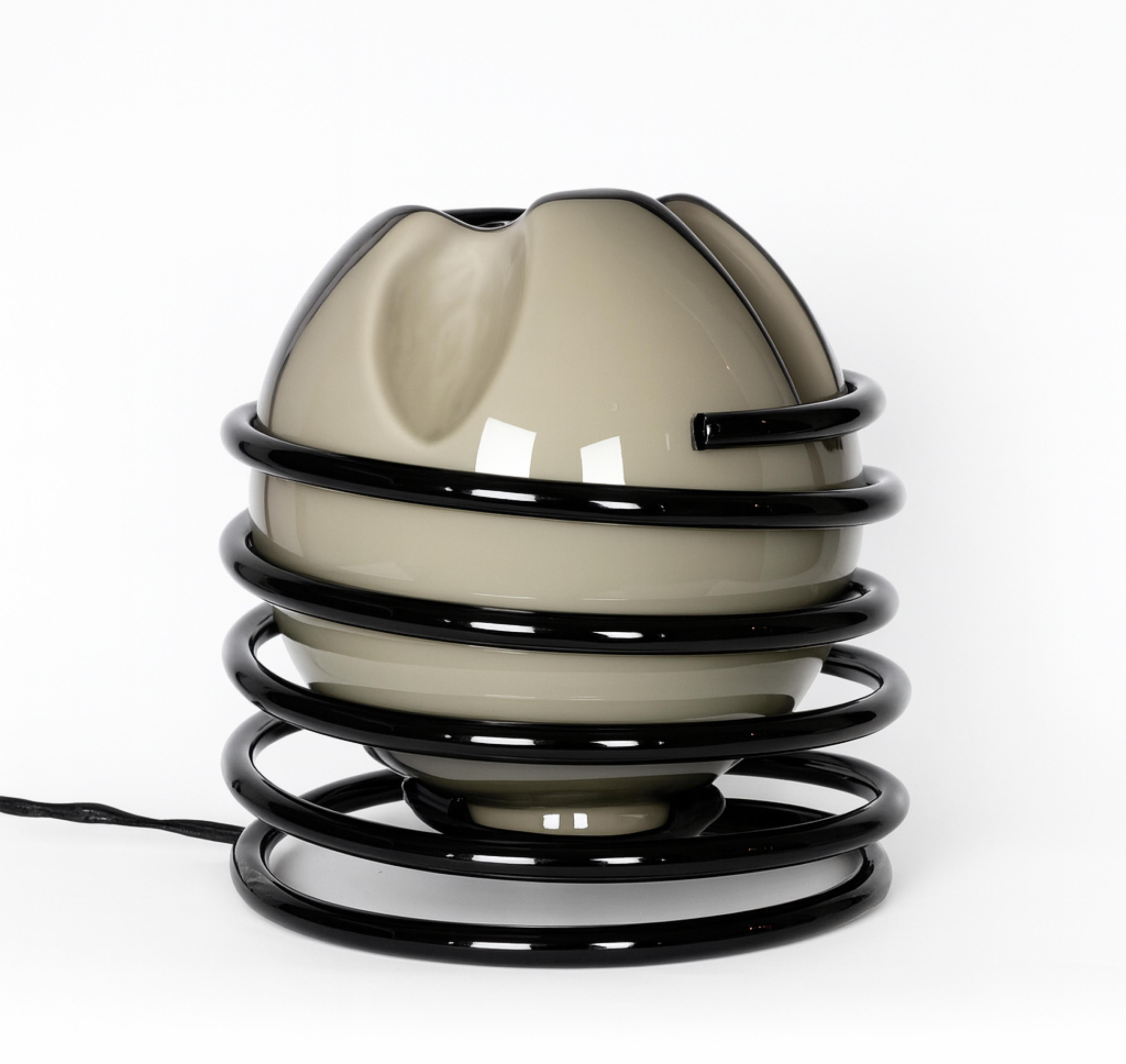 Lampe de table italienne moderne du milieu du siècle, en laque noire, avec une boule ronde en verre gris entourée d'une spirale en métal chromé. 

Ses petites dimensions en font un complément idéal pour les espaces compacts ou comme pièce d'accent
