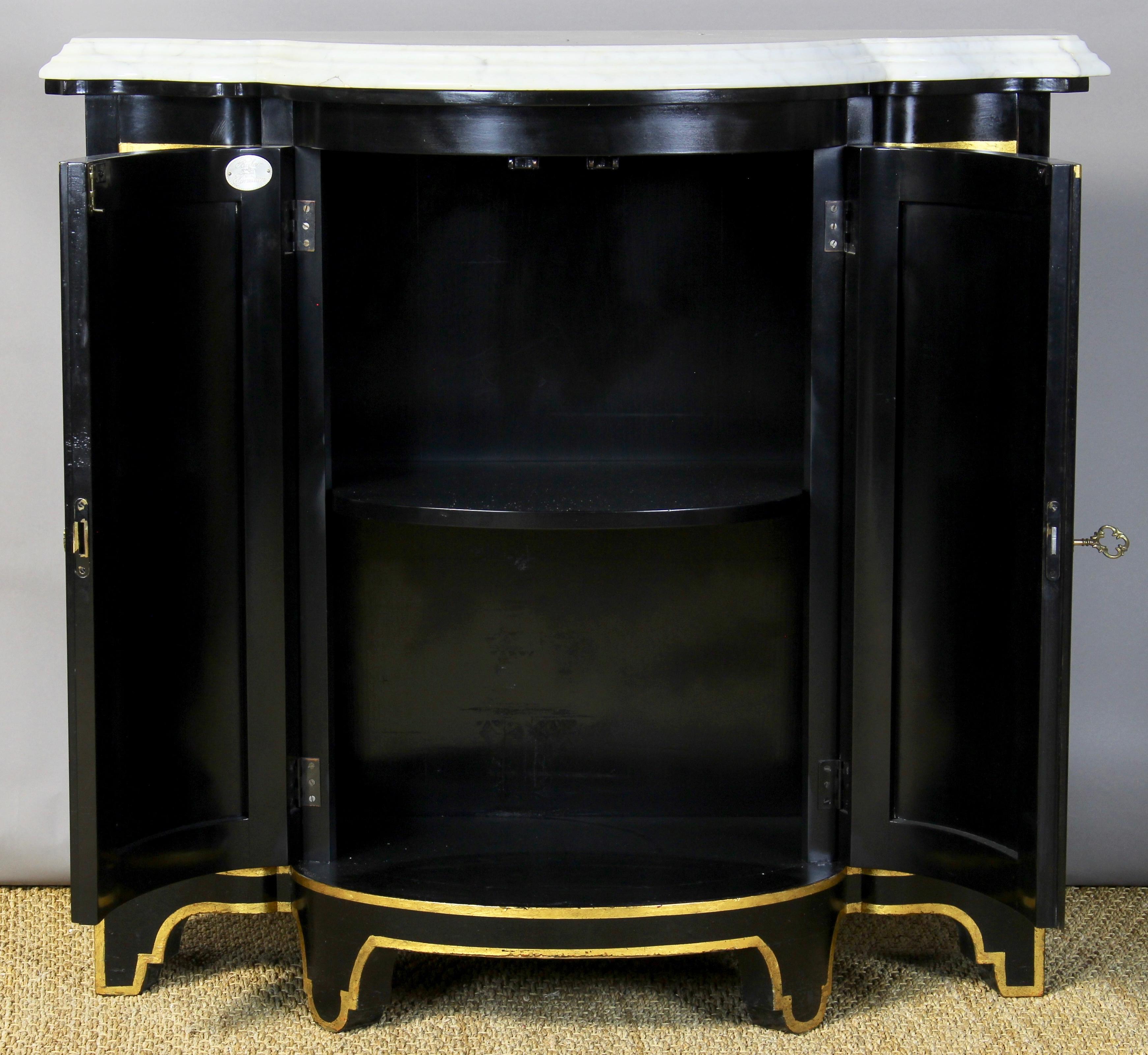 A late 20th century black lacquer and gilt accented 2-door credenza with thickly cut Carrara marble top manufactured by Baker.