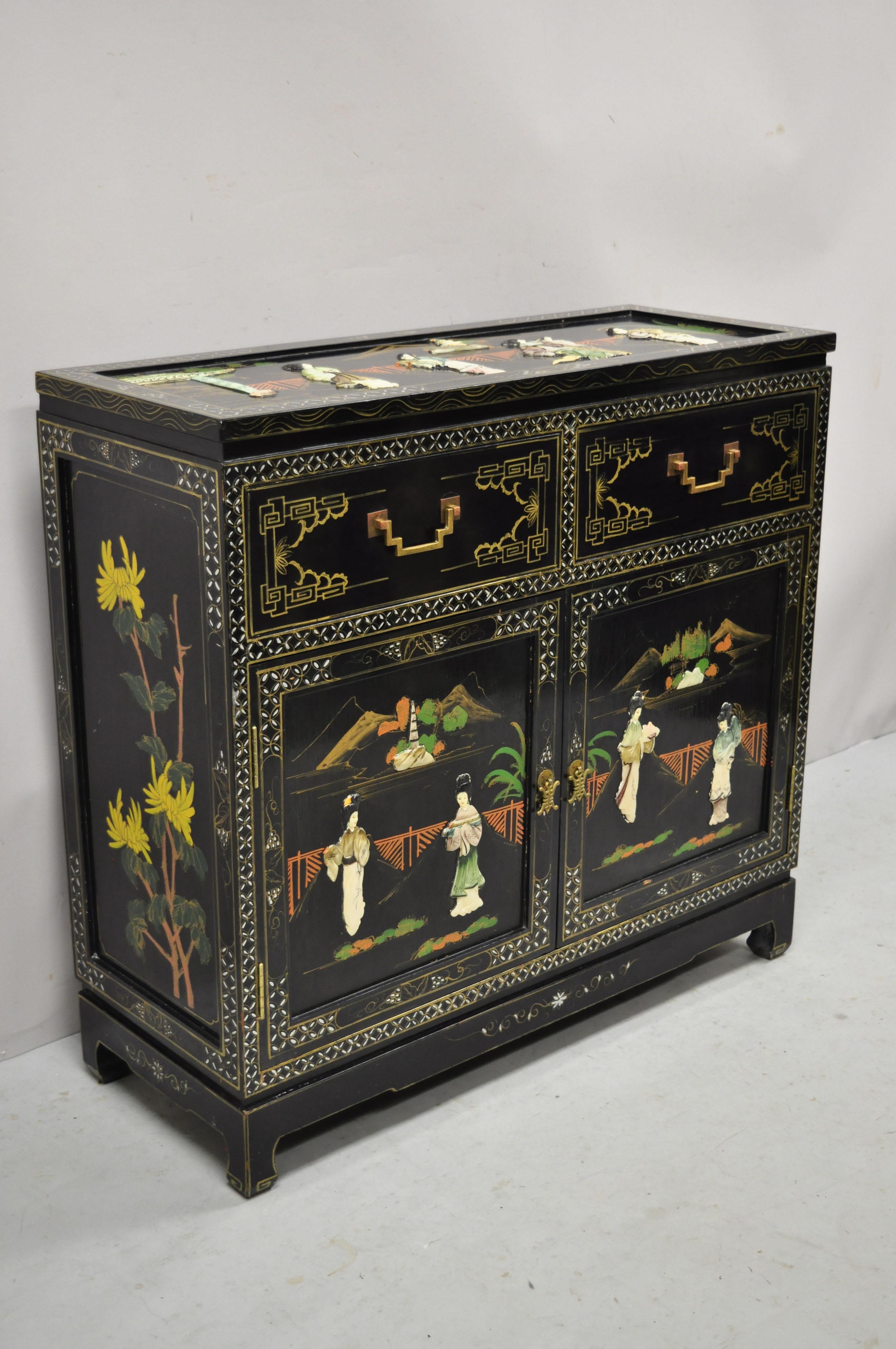 Vintage black lacquer oriental Chinese Export carved soapstone figural buffet cabinet. Item features carved soapstone figures, black lacquer finish, 2 swing doors, 2 drawers, solid brass hardware, great style and form. Circa mid to late 20th