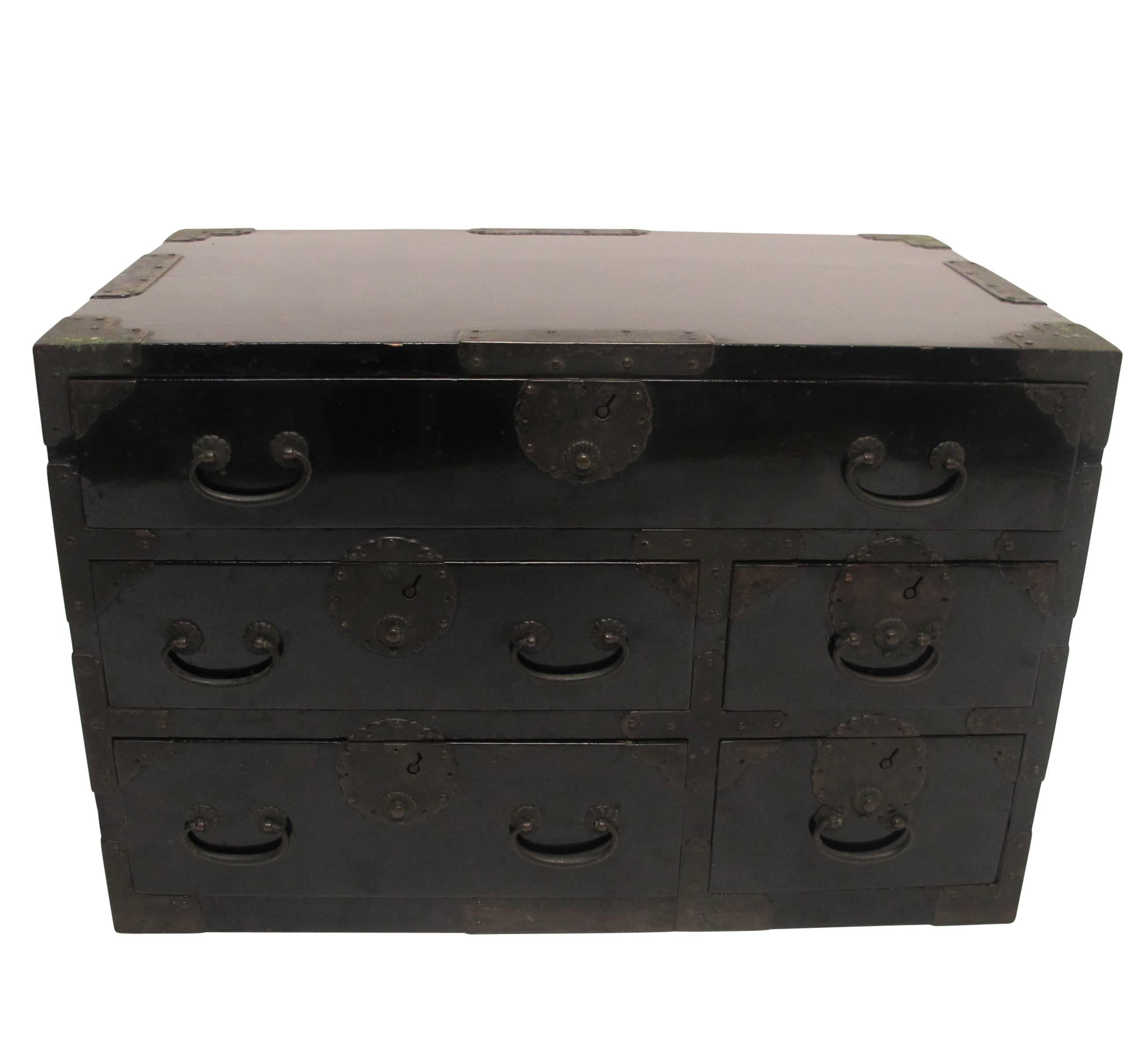 A small beautifully black lacquered tansu chest with original hardware and having seven drawers. Japan, late 19th-early 20th century.