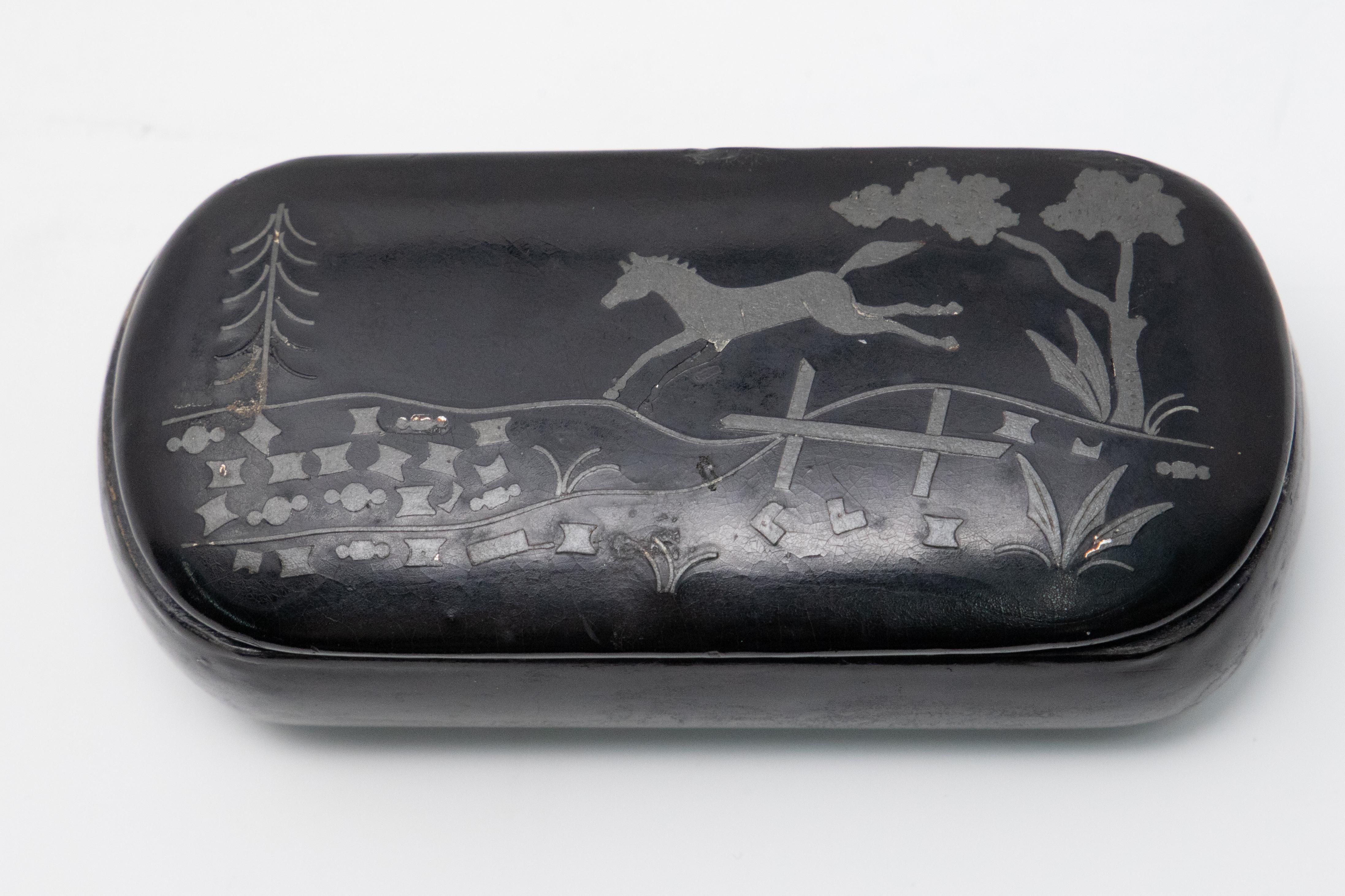 Gorgeous black lacquered snuff box with jumping horse scene. The scene is painted in enamel paint. The inside of box has zinc liner.