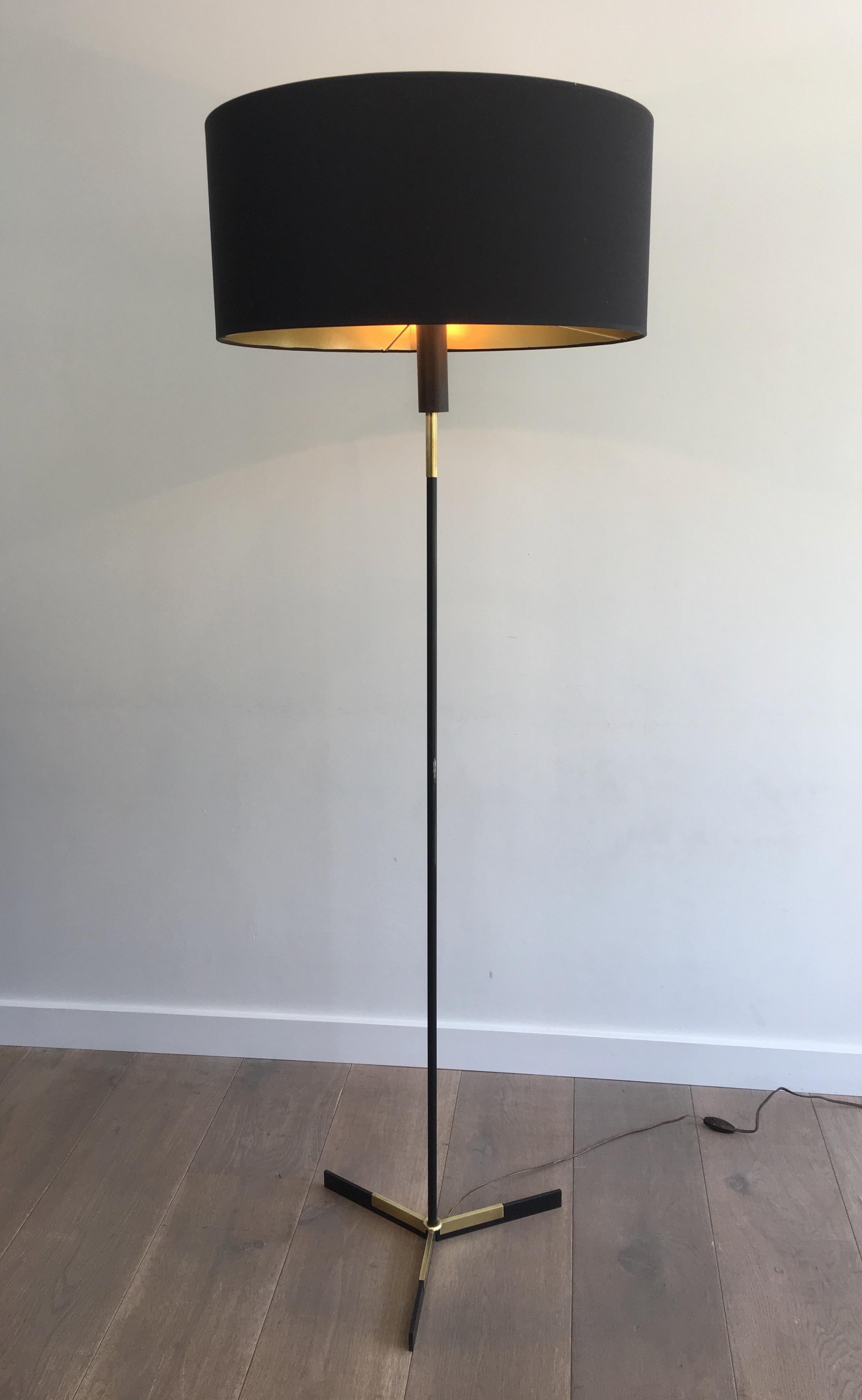 This very nice design floor lamp is made of brass and black lacquered brass. This is a French work, circa 1950.
