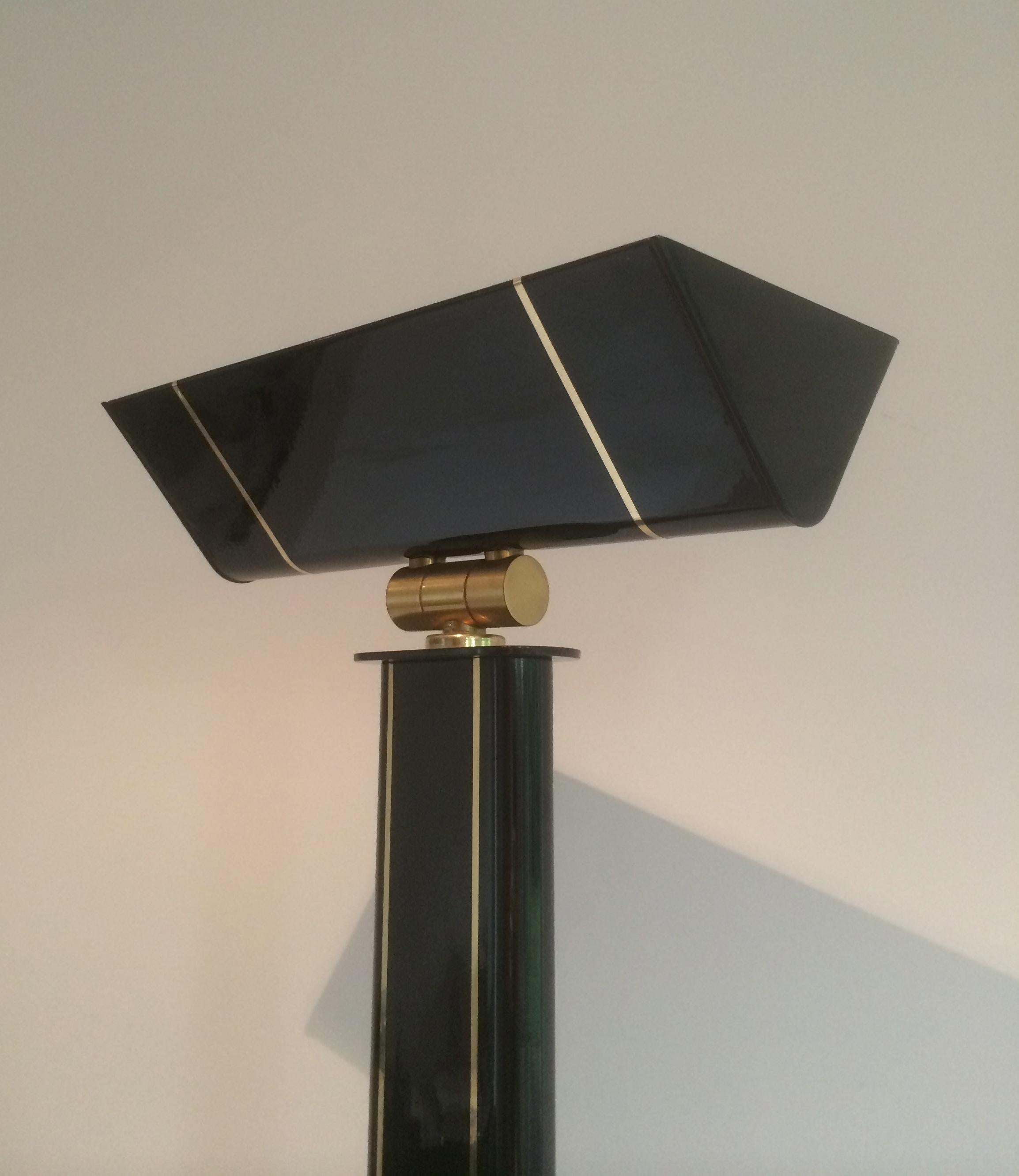 This very elegant floor lamp is made of black lacquered metal and brass. This is an halogen floor lamp. This is a French work. Circa 1970.
