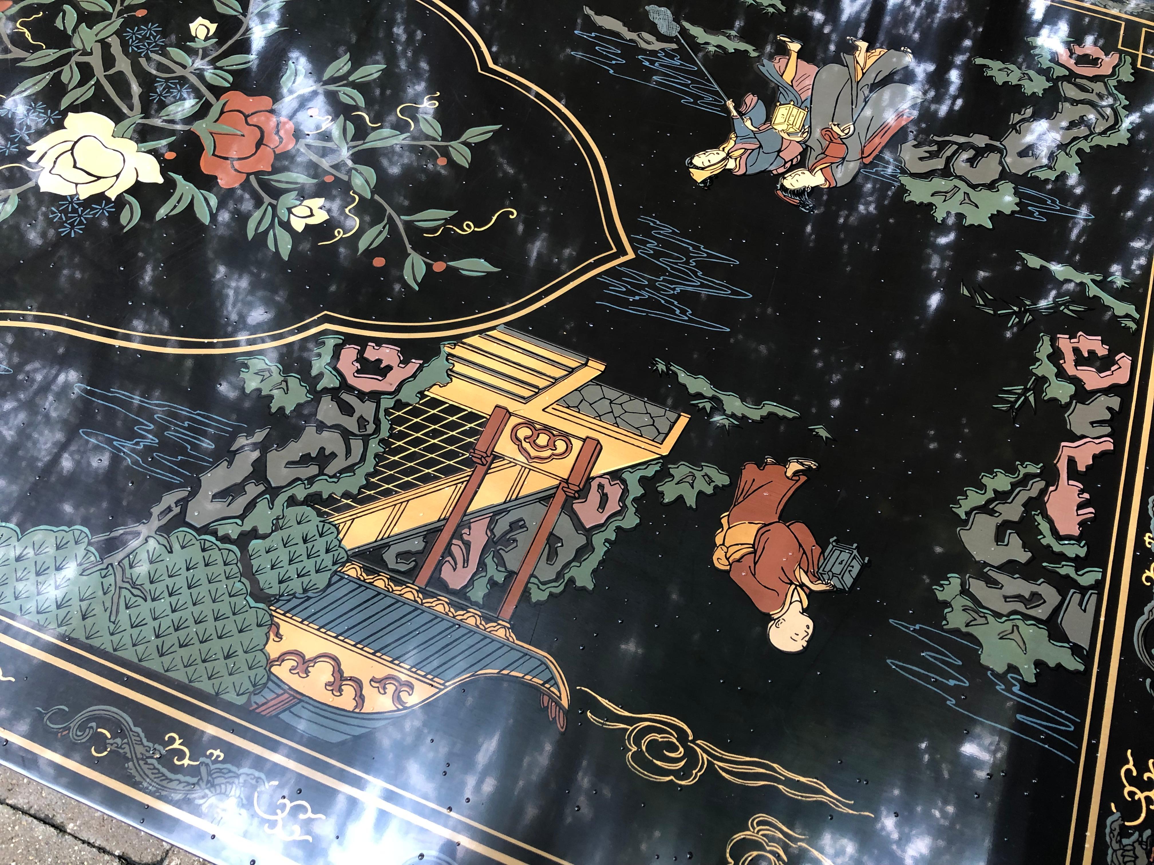 A lacquered coffee table by Drexel Heritage in an oriental chinoiserie taste. It features squared hardwood legs supporting a black lacquered top with raised edges. The delicate design on the top surface was masterly done with oriental figures in a