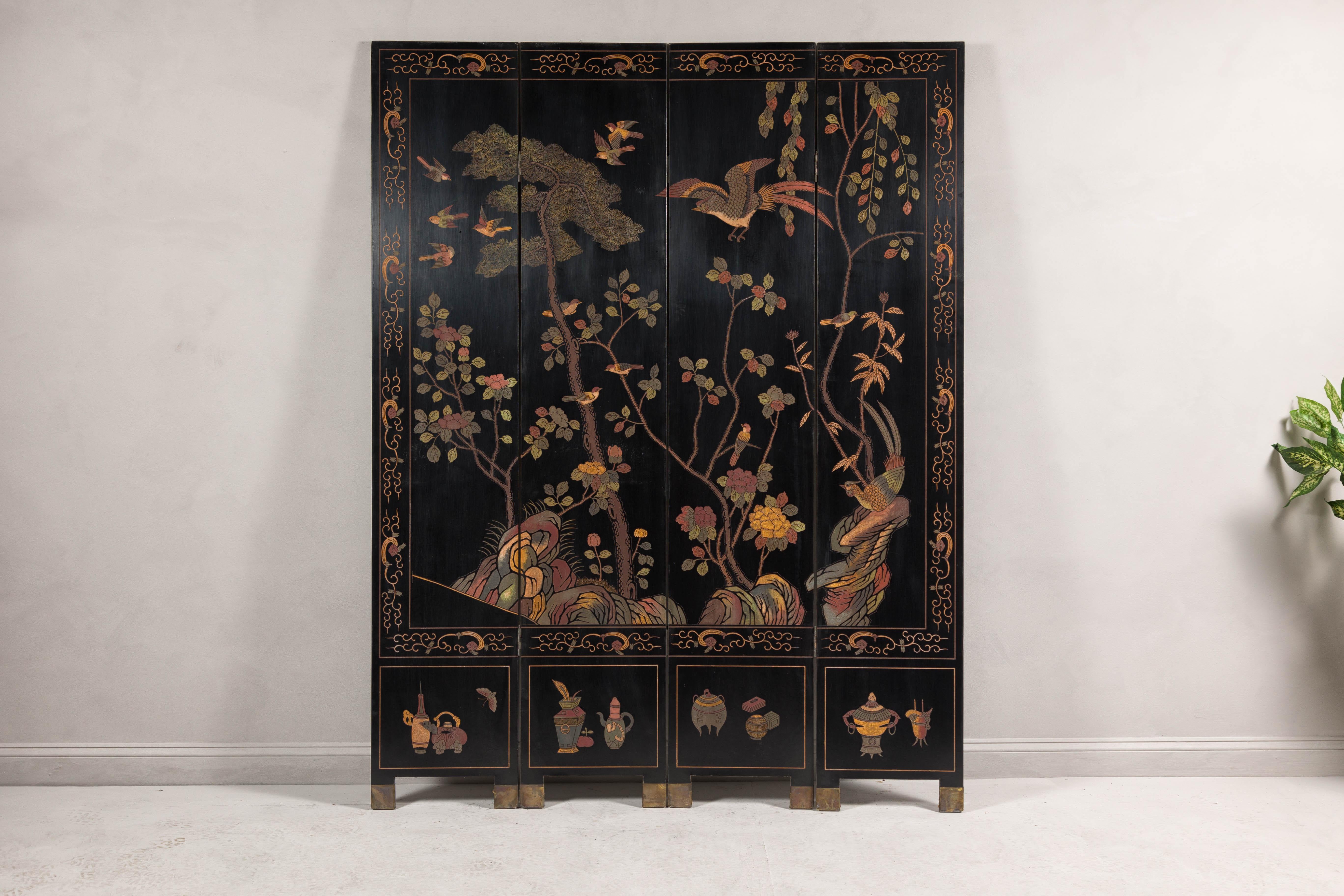 A vintage black lacquered four-panel screen with polychrome décor showcasing birds, trees, foliage and rocks. This vintage black lacquered four-panel screen, originating from China, presents an exquisite polychrome decoration of birds, trees,