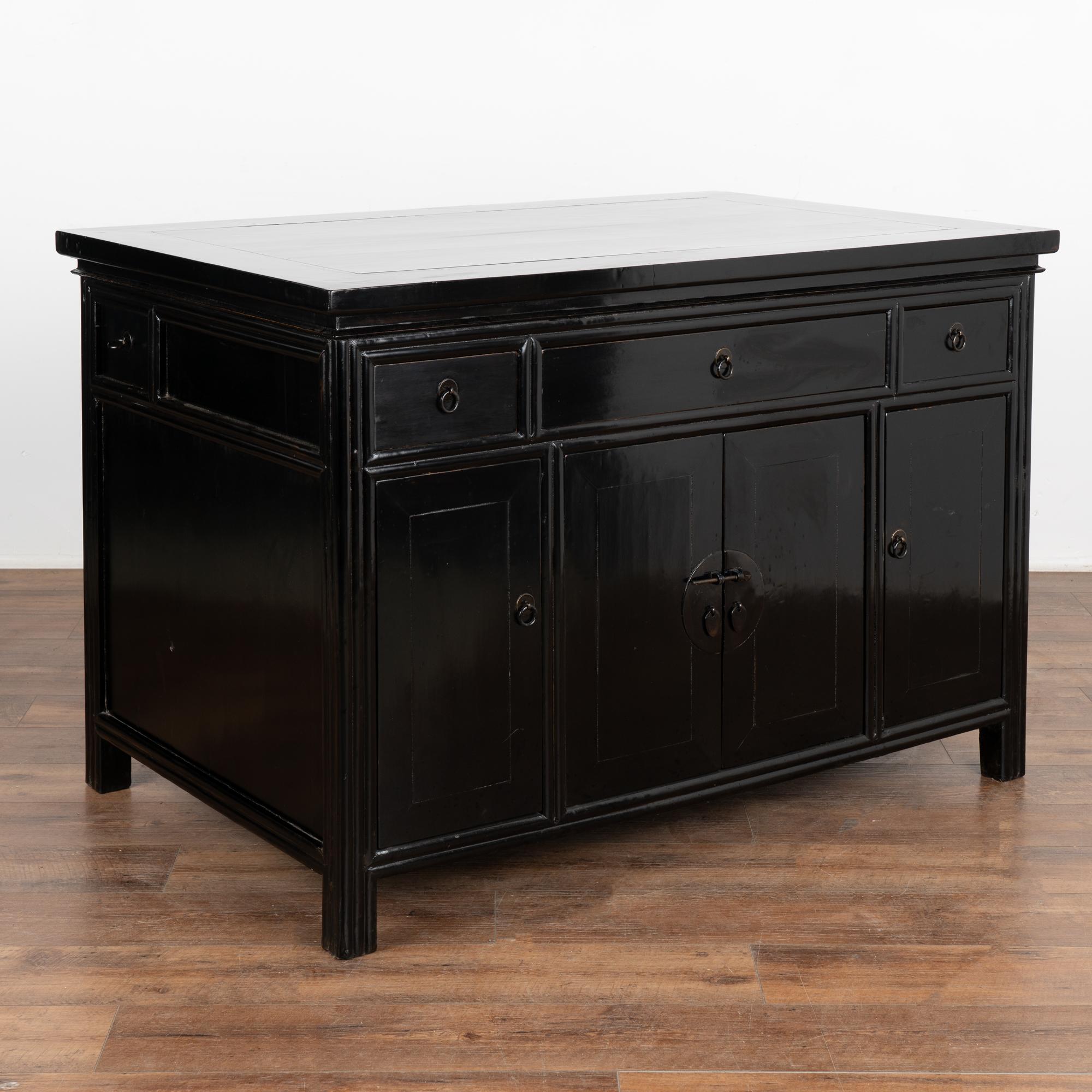 The black lacquered polished finish on this antique Chinese cabinet provides a modern look allowing this to serve well in a contemporary setting. This free standing cabinet will be a stylish statement piece for a central entryway or even serve as a