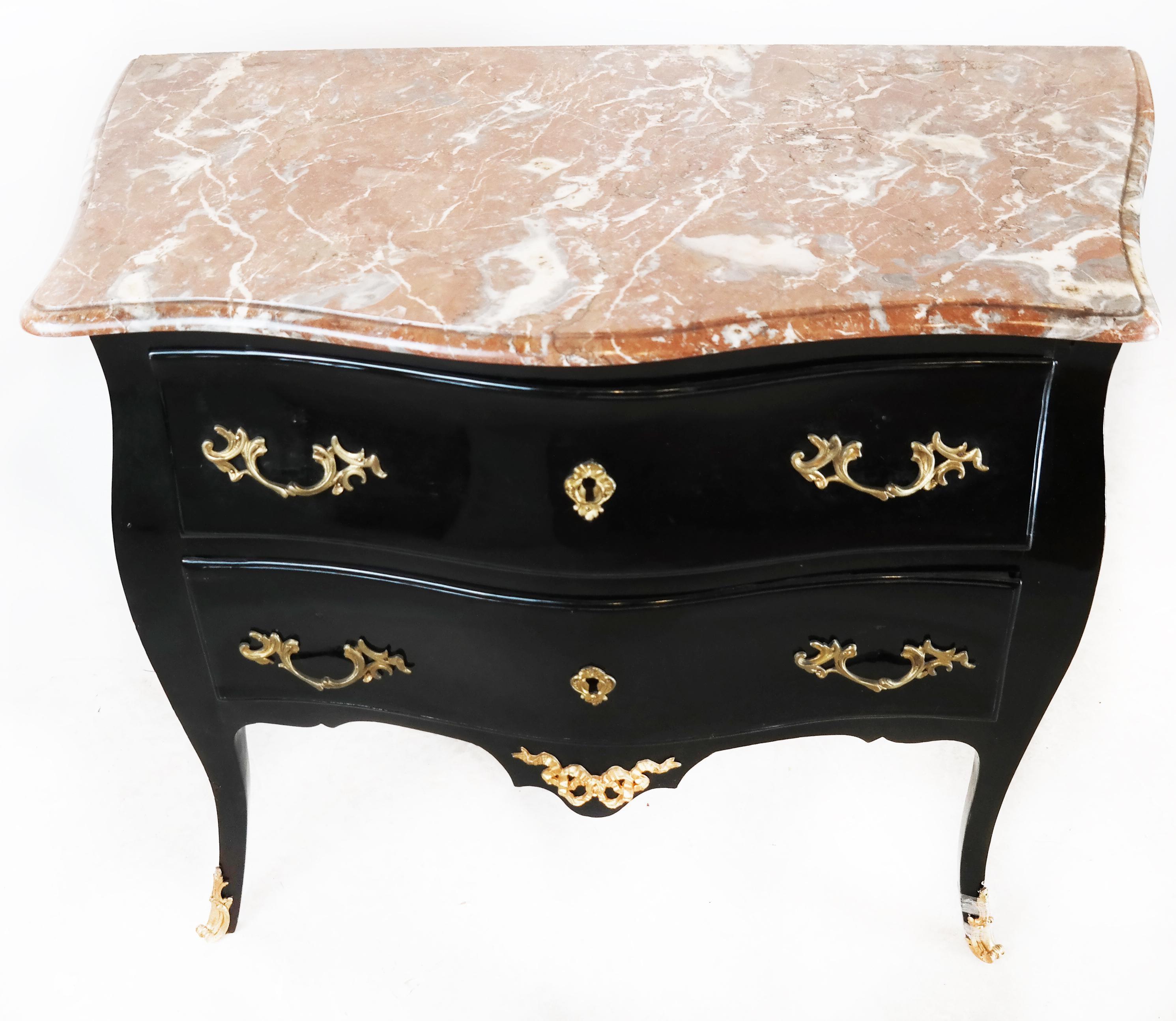 Black lacquered French bombe shape commode with brass details to drawers and feet and a coral tone marble top