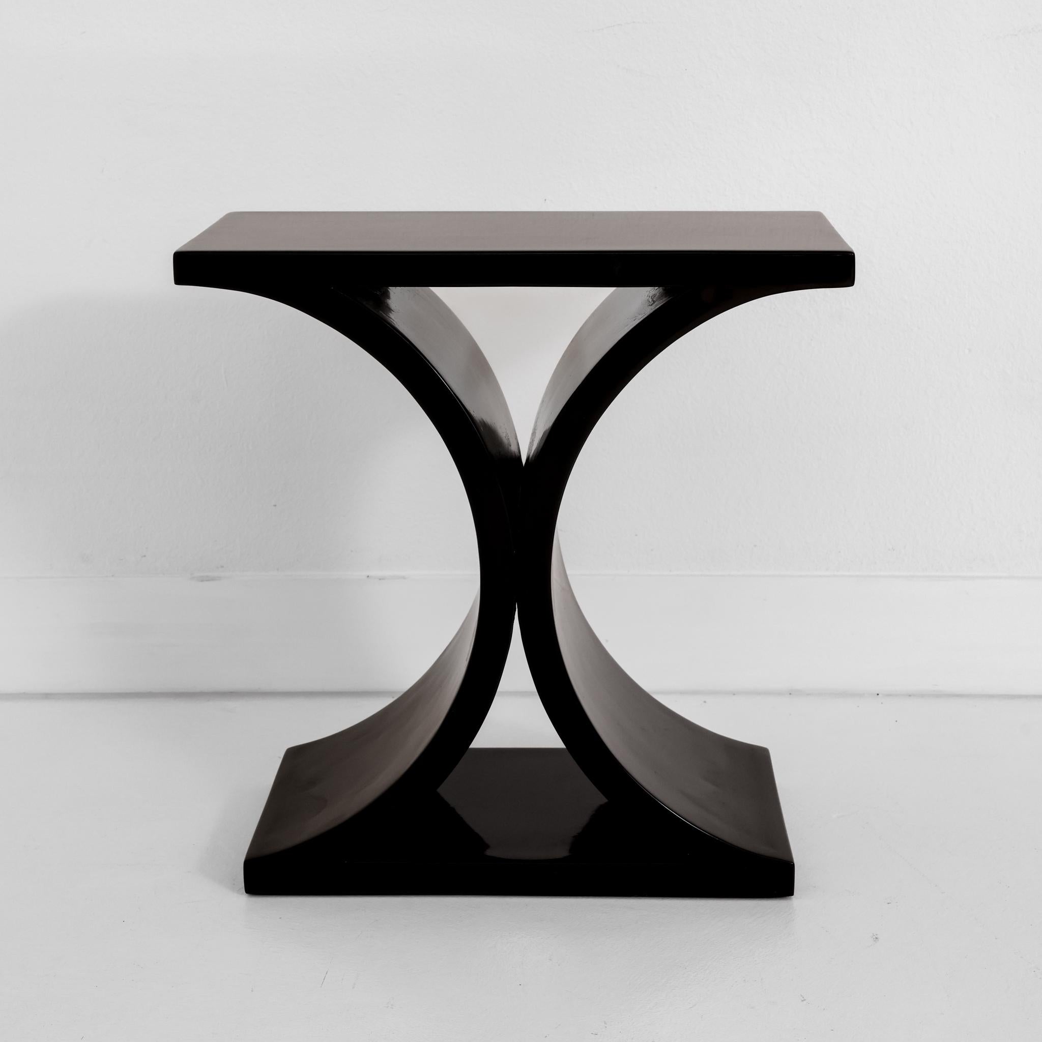 This is a rare black lacquered JMF side table by Karl Springer. The table has the classic JMF half circle/flared base. The JMF consoles in this style are more readily available, however the end tables are harder to find making this a unique