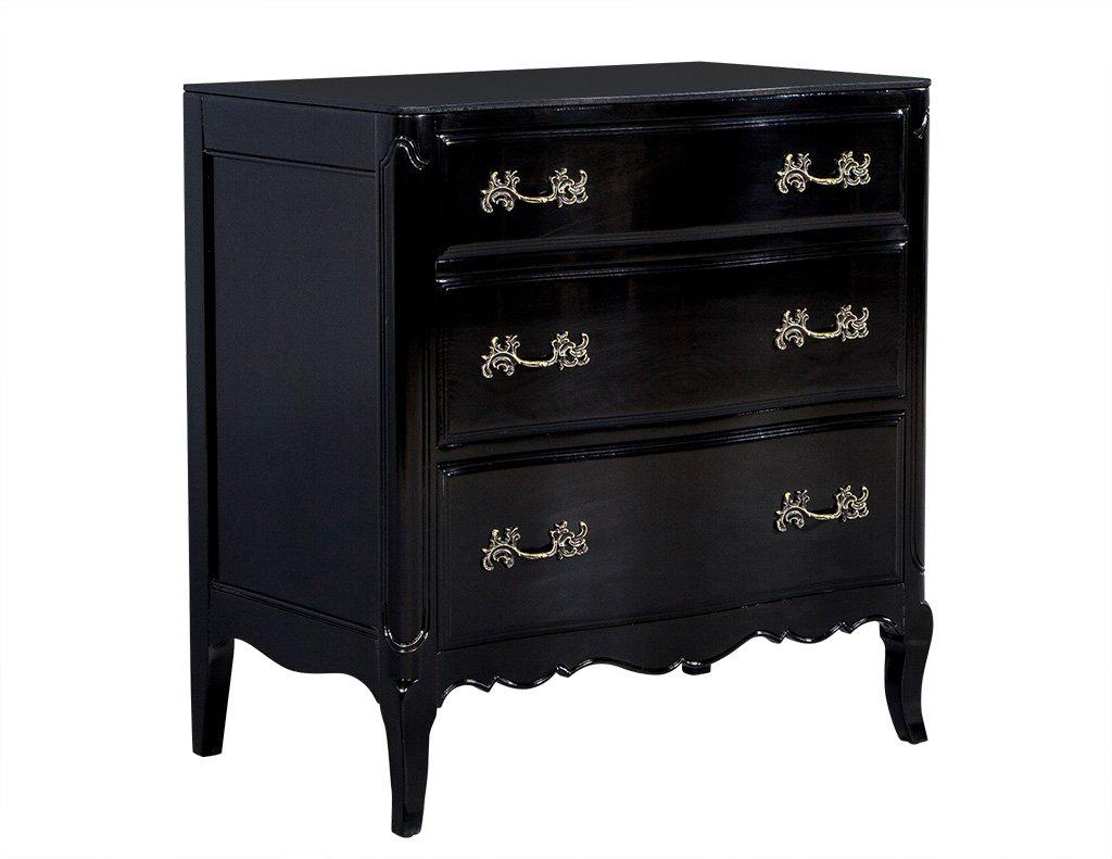 Part of the Carrocel Revival Collection, this chest has been restored and finished in Obsidian hand polished lacquer. Designed with undulating curves this chest has a glass top and saber legs, three drawers break up the facade of the piece adorned