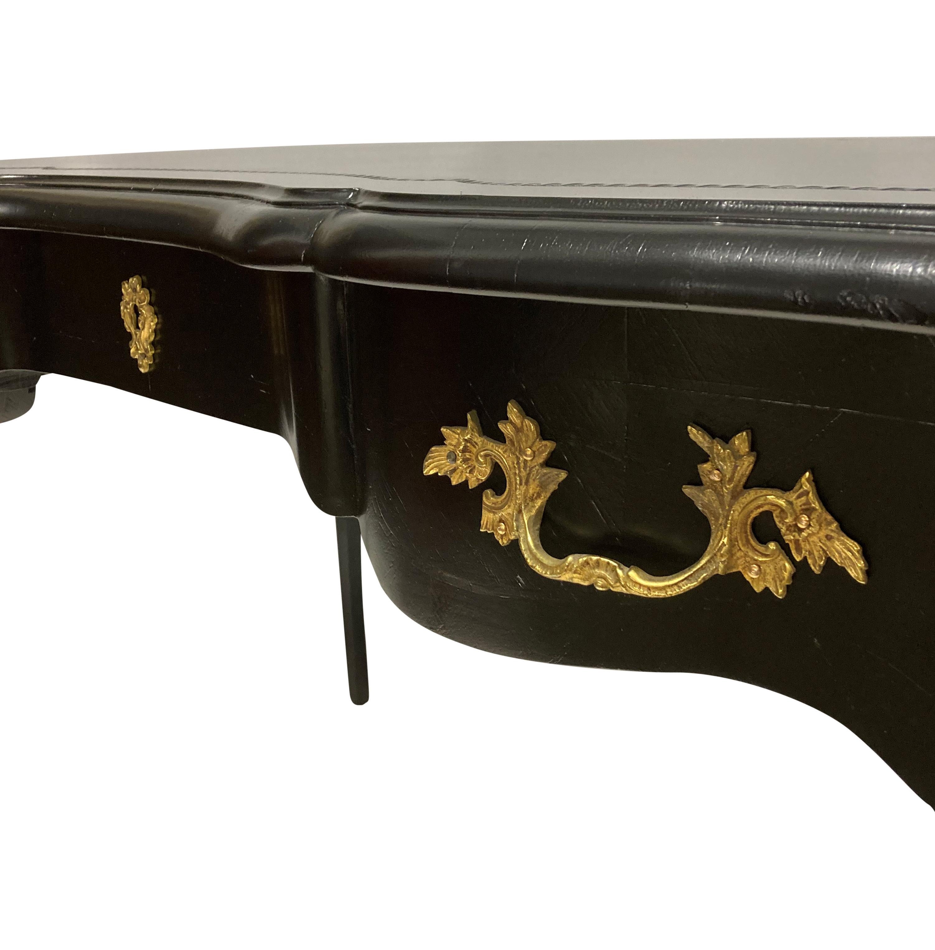 Table à écrire ou bureau plat de style Louis XV laqué noir. Avec trois tiroirs fonctionnels, y compris les tiroirs à clé et les tiroirs aveugles d'origine à l'avant. Il est orné de fines montures en bronze doré et d'un couvercle en cuir noir façonné