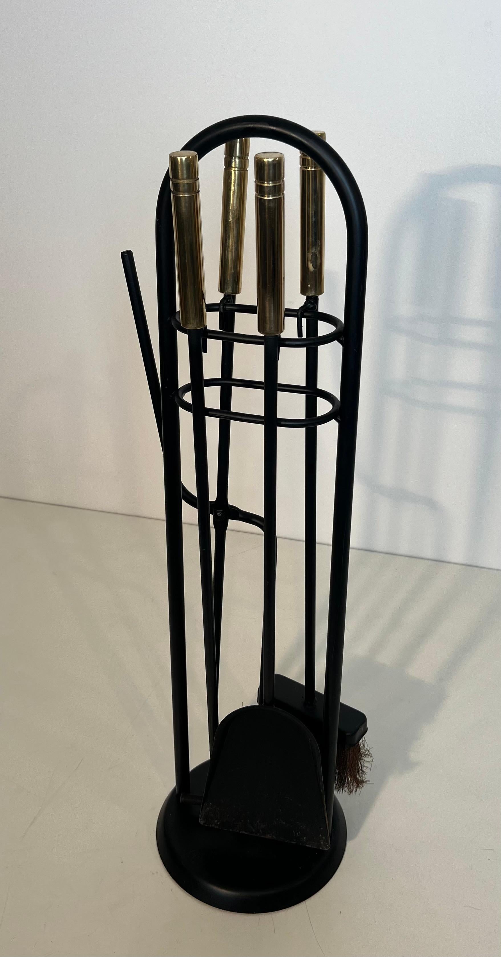 Questo simpatico strumento per caminetto con supporto è realizzato in metallo laccato nero e ottone. Questa è un'opera francese. Circa 1970