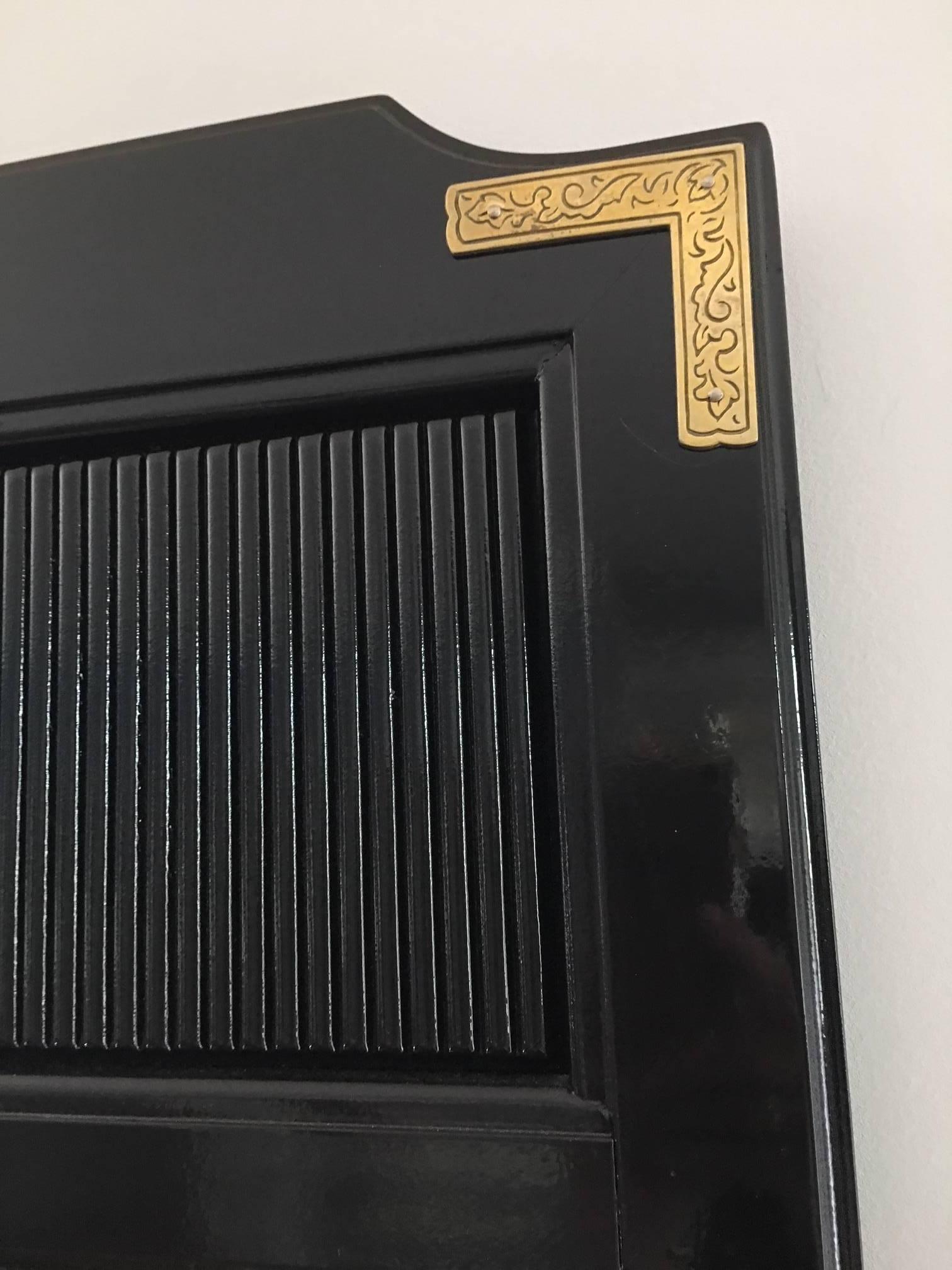 This perfect black mirror will go almost anywhere in your home. Great size to top a dresser, console, or entry table. Etched brass corners.